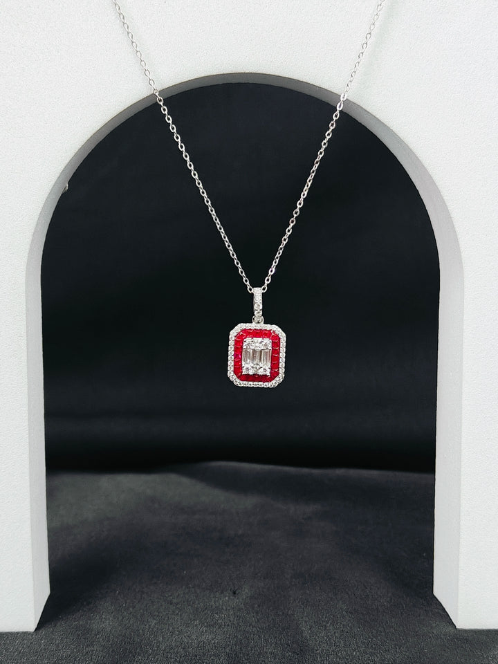 Diamond necklace with a red gemstone pendant on a dark background