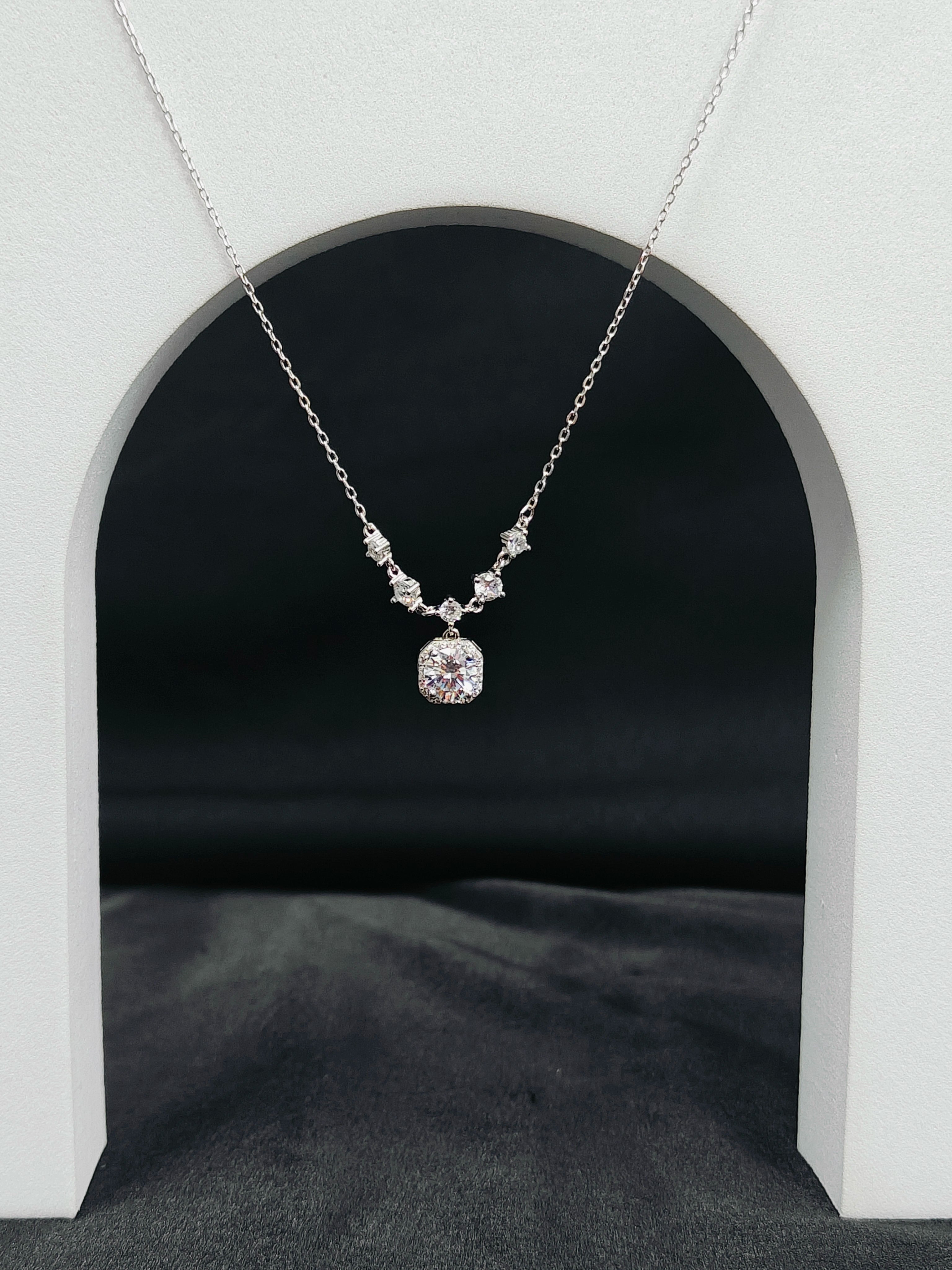 Silver necklace with a pendant on a dark background