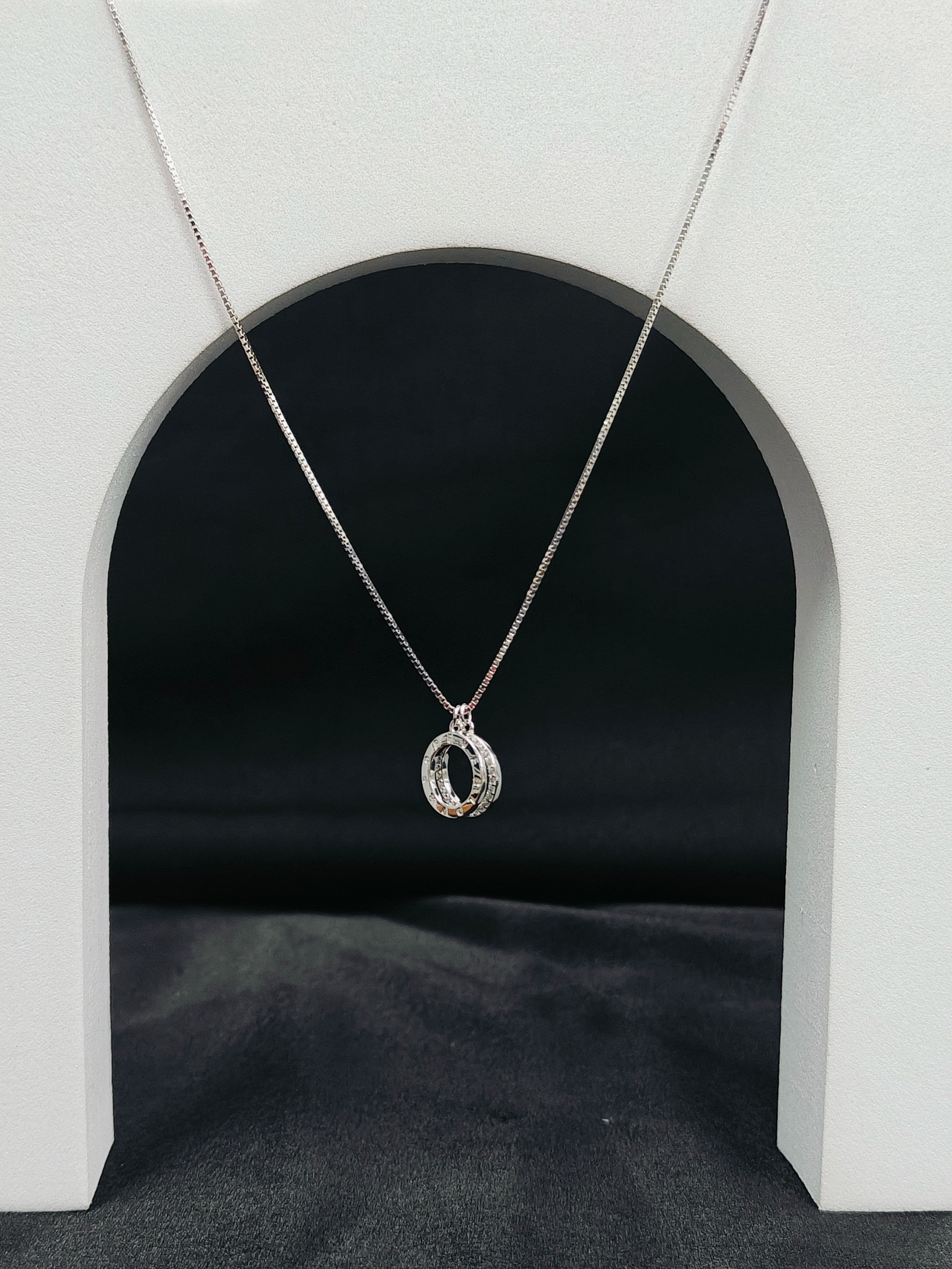 Silver necklace with a pendant on a black background