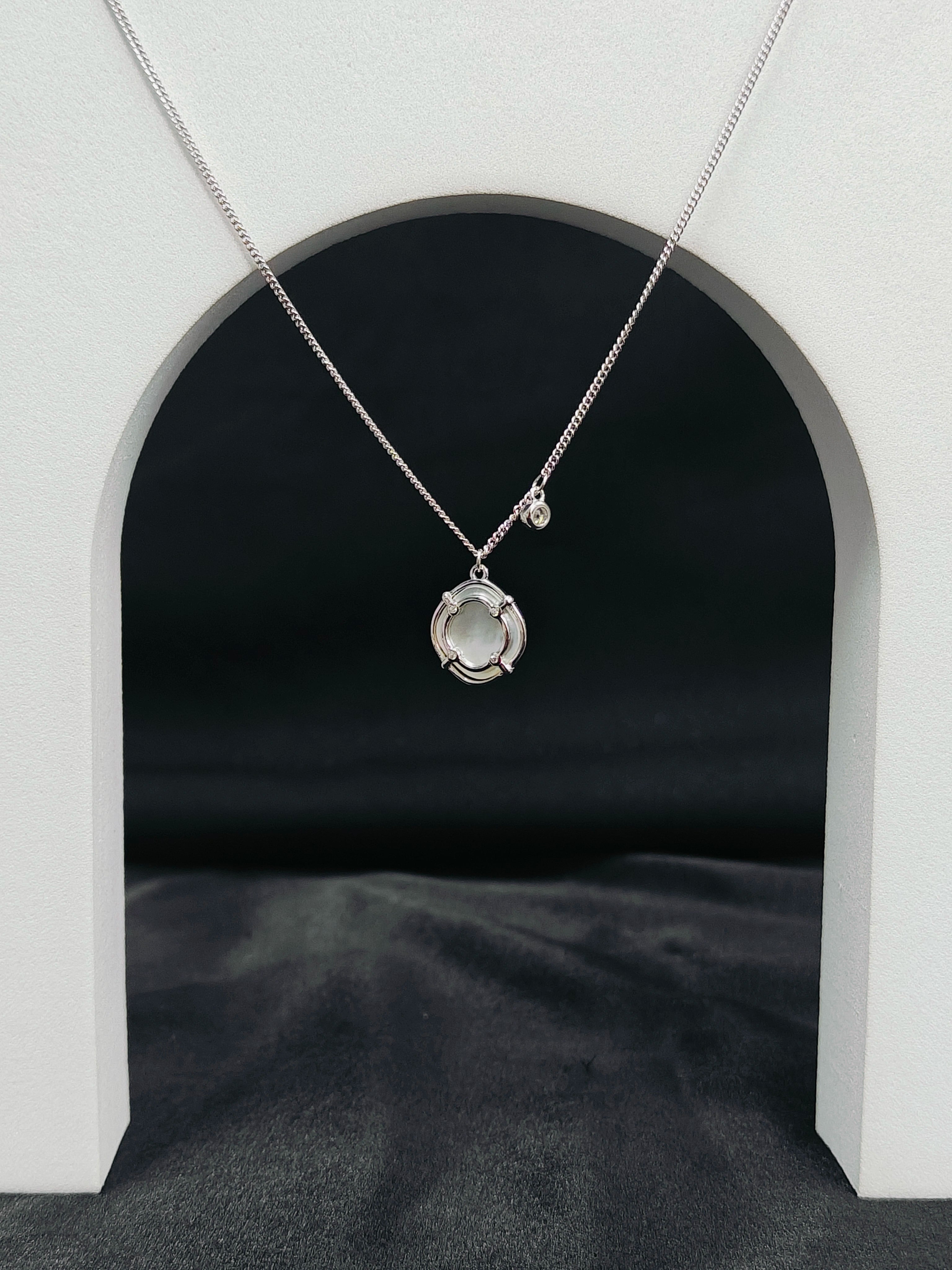 Silver necklace with a pendant on a dark background