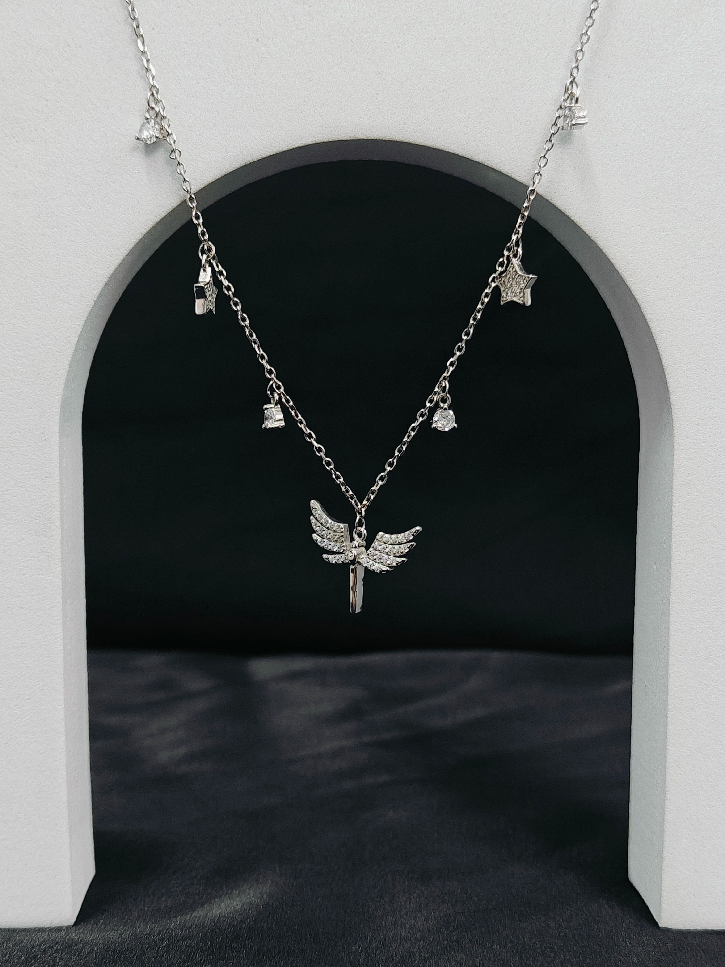 Silver necklace with angel wing pendant on a dark background
