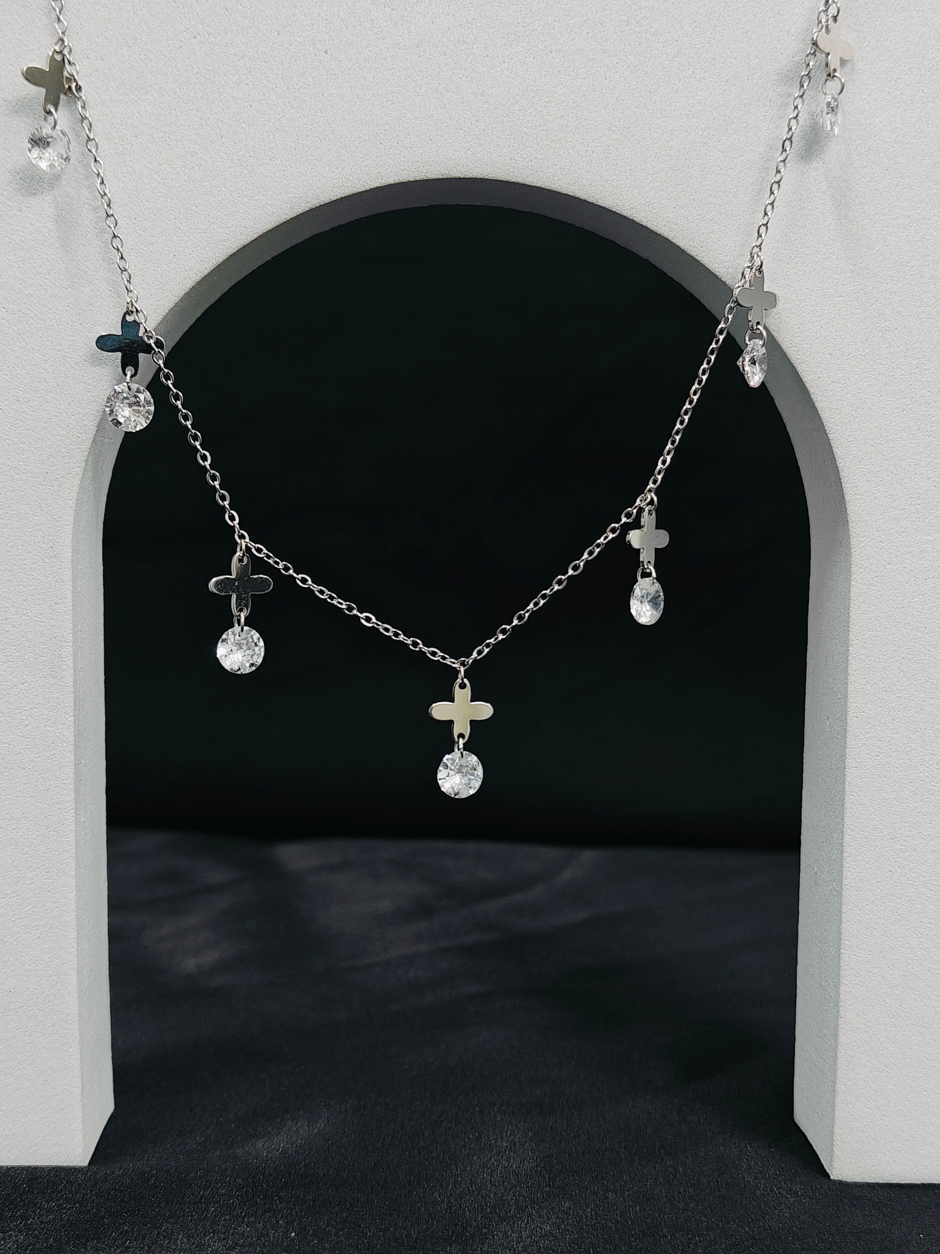 Necklace with small pendants hanging in front of a black archway
