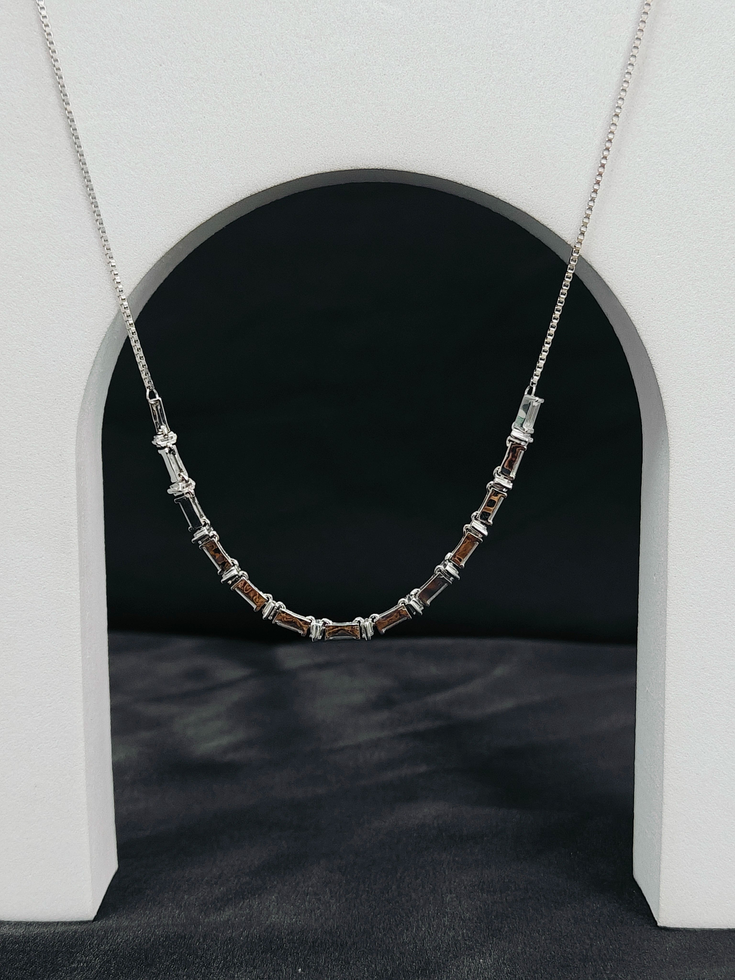 Silver necklace with beads on a dark background