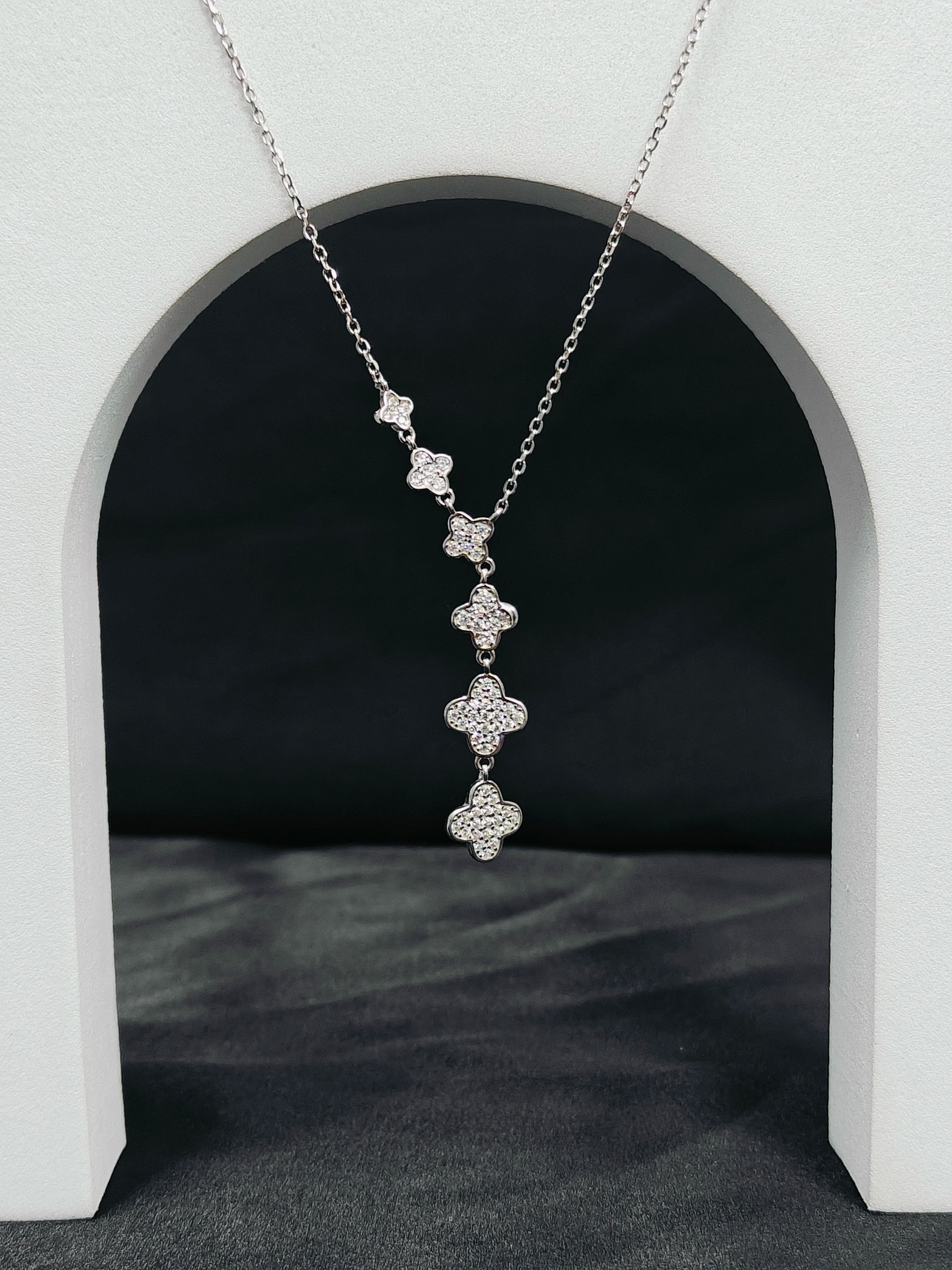 Silver necklace with floral pendant on a dark background