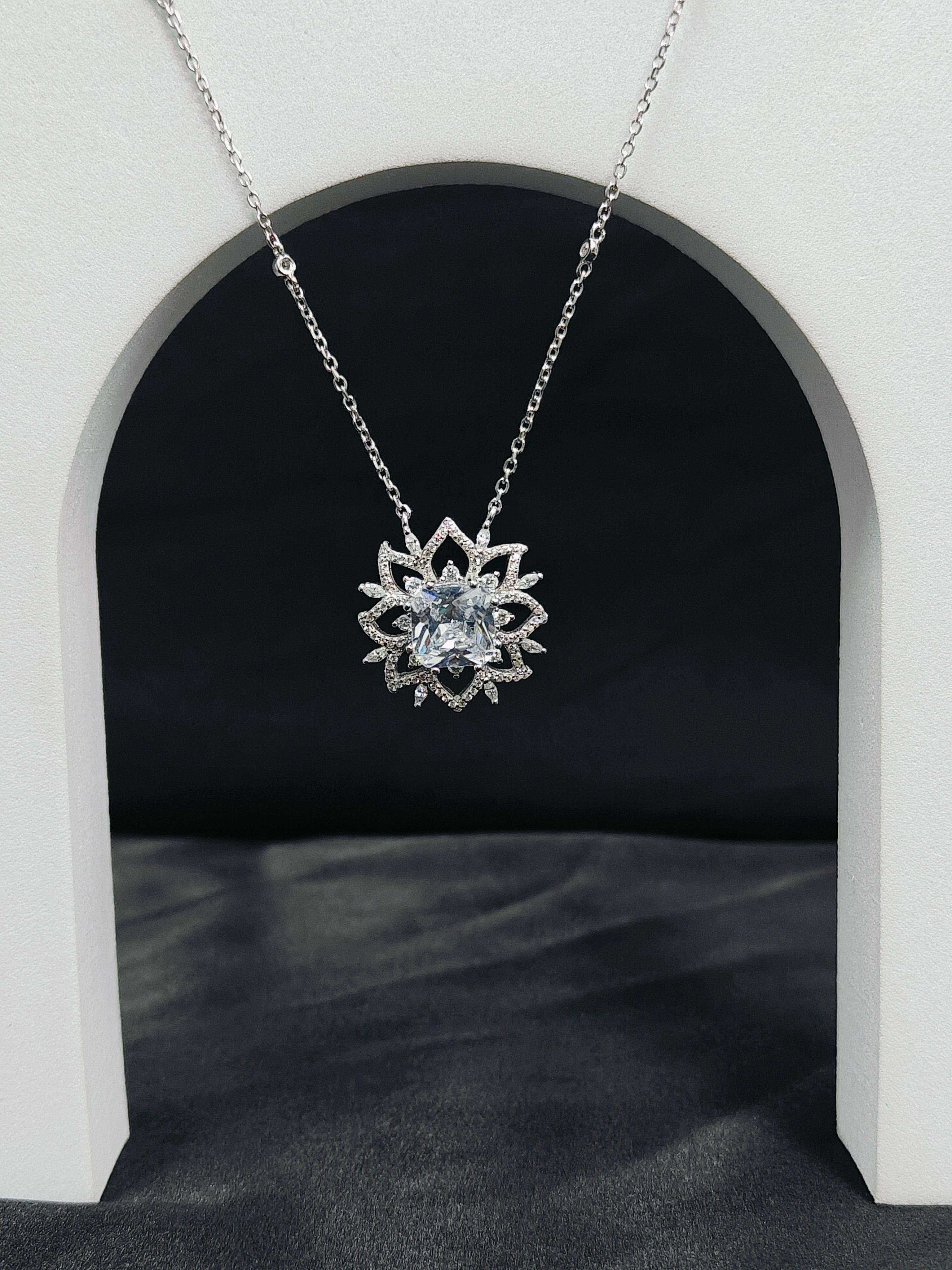 Silver lotus flower pendant necklace on a dark background