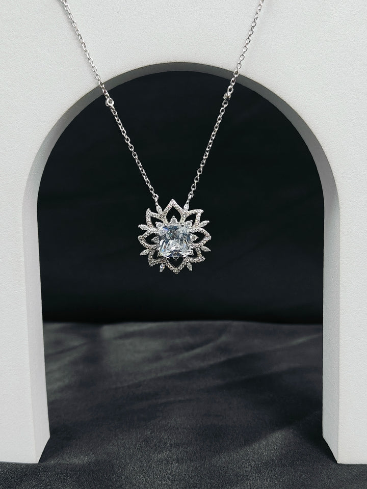 Silver lotus flower pendant necklace on a dark background