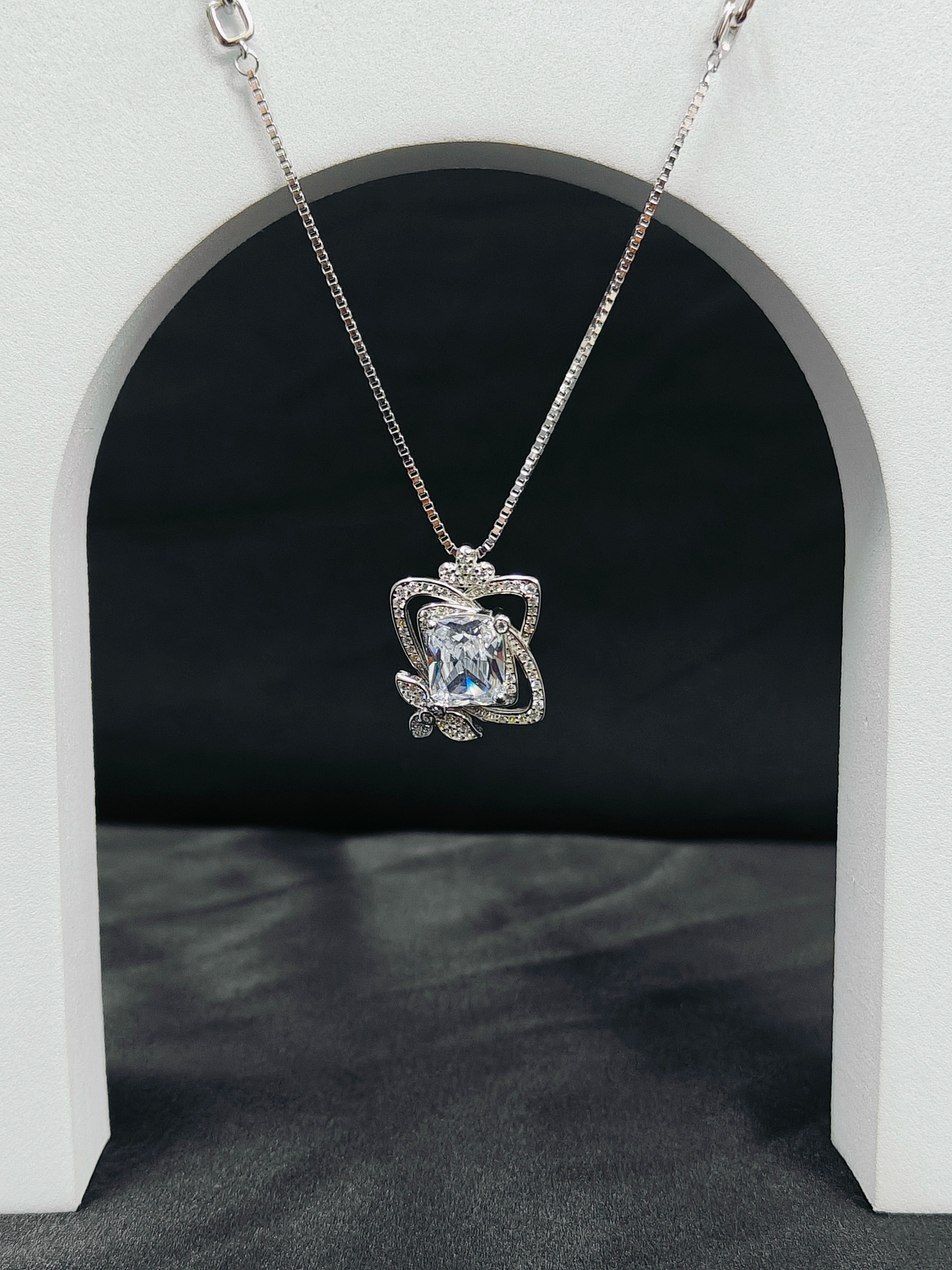 Silver necklace with a blue gemstone pendant on a black background