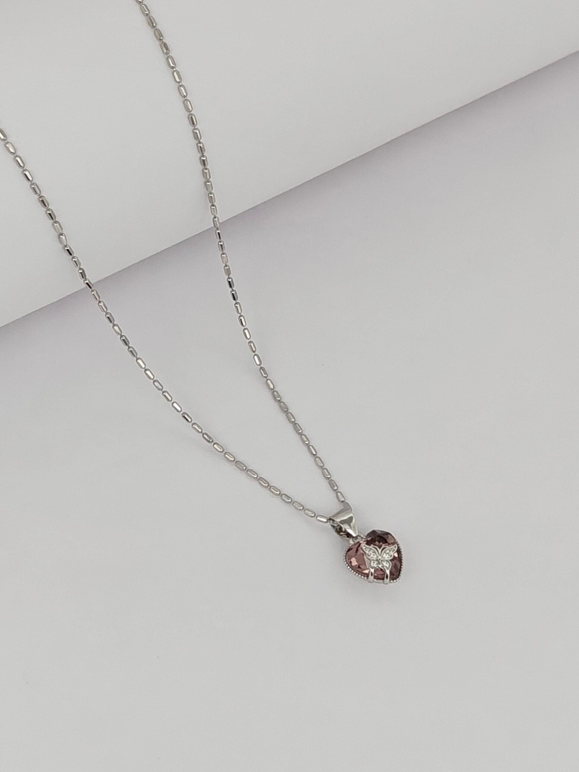 Necklace with a pink gemstone pendant on a light gray background
