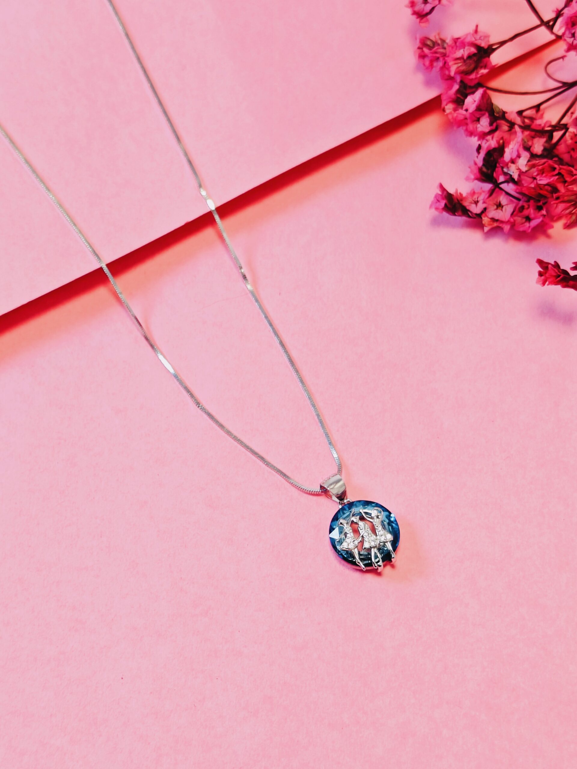 Necklace with a colorful pendant on a pink background