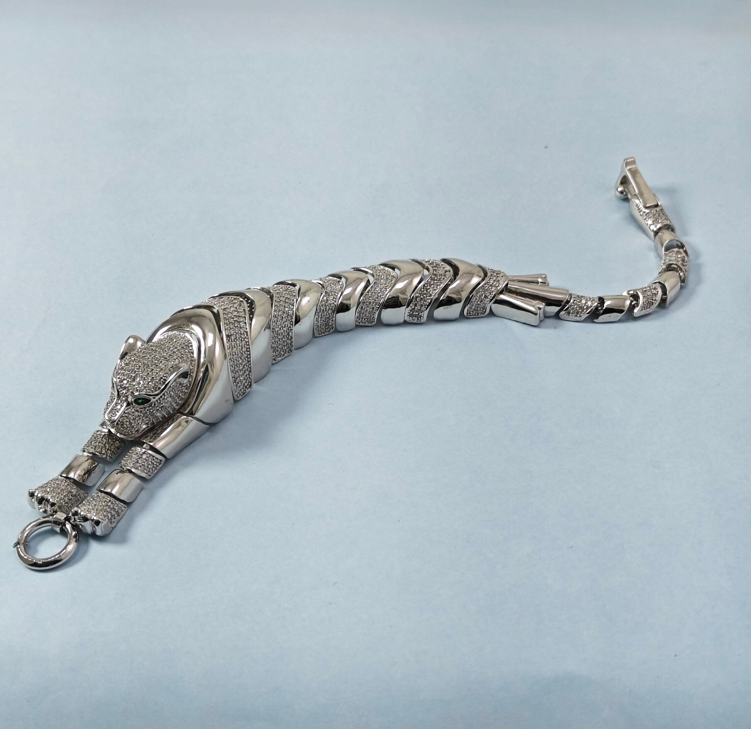 Silver bracelet with panther design on a light gray background