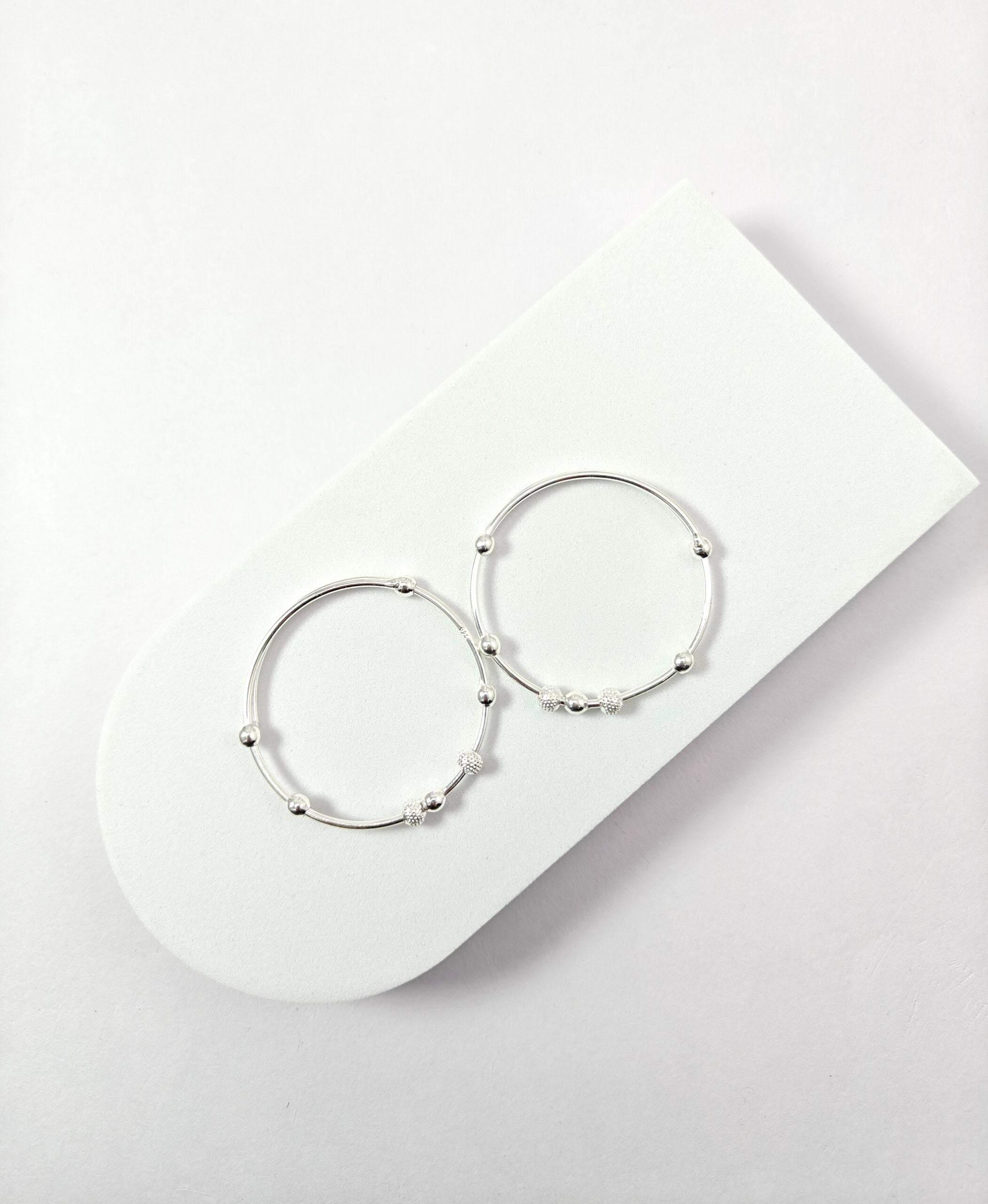 Pair of silver hoop earrings on a white surface