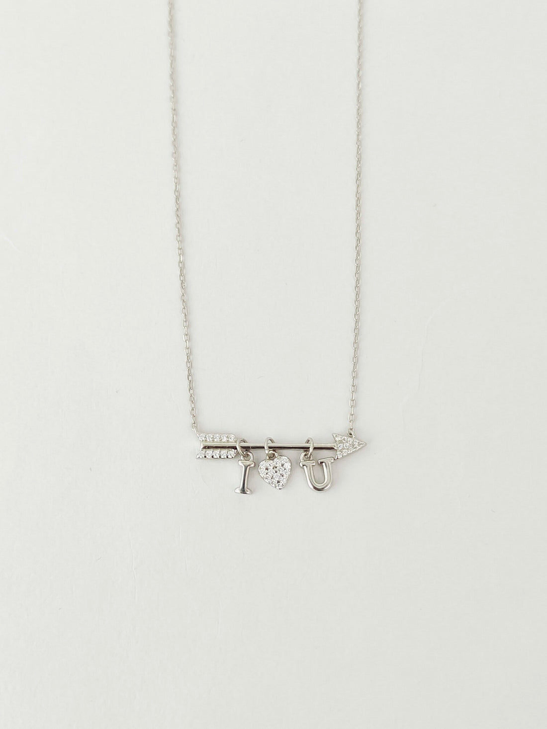 Silver necklace with a pendant on a light gray background