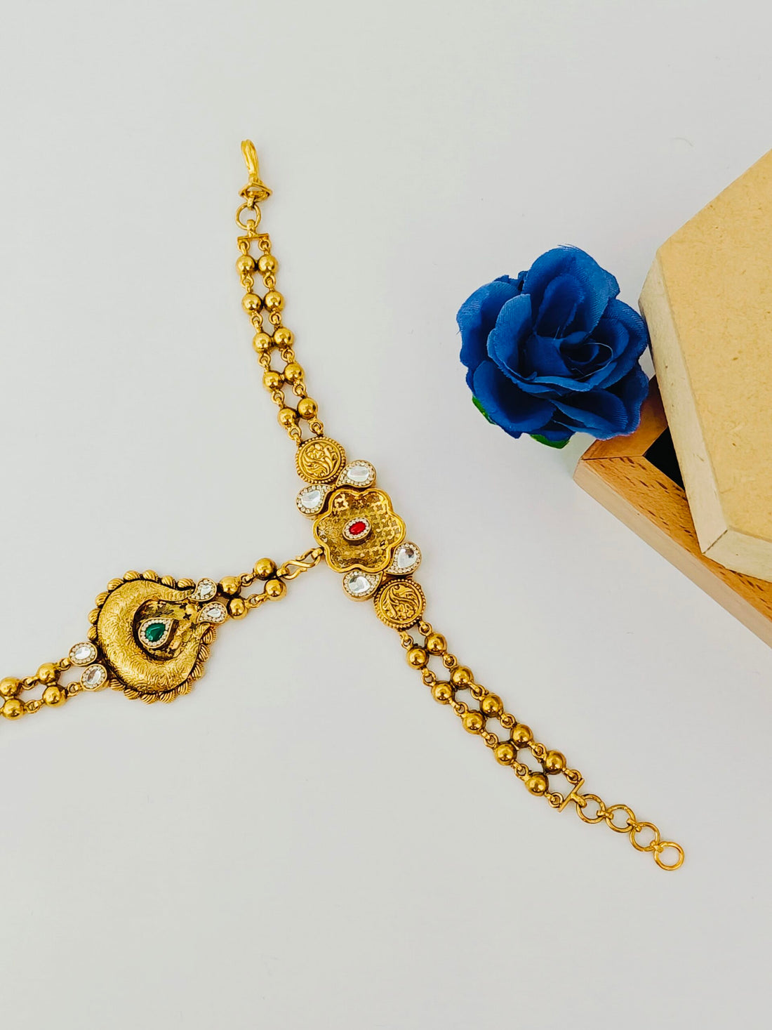 Gold bracelet with decorative elements on a white background