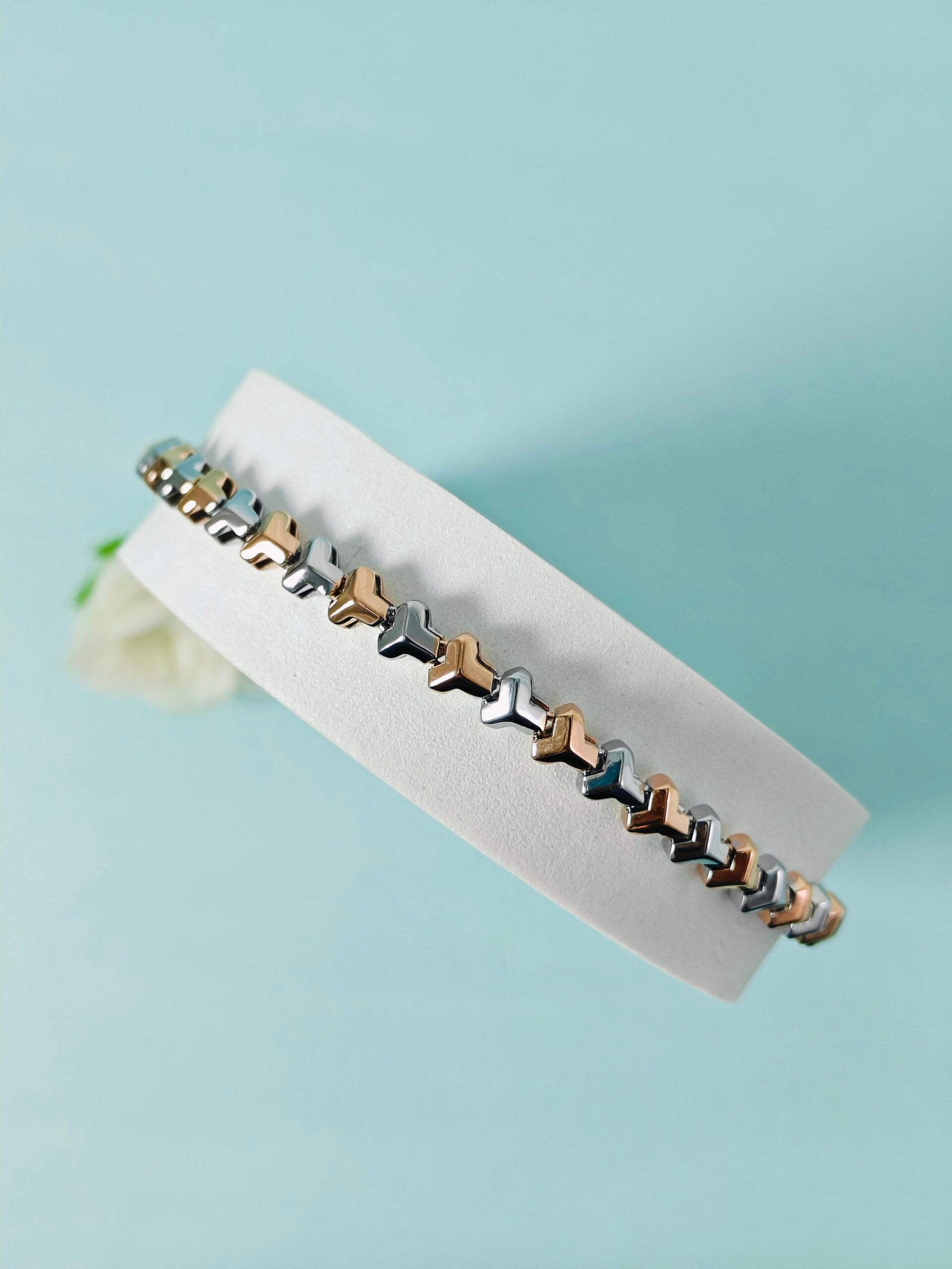 Bracelet with star-shaped beads on a white card against a light blue background