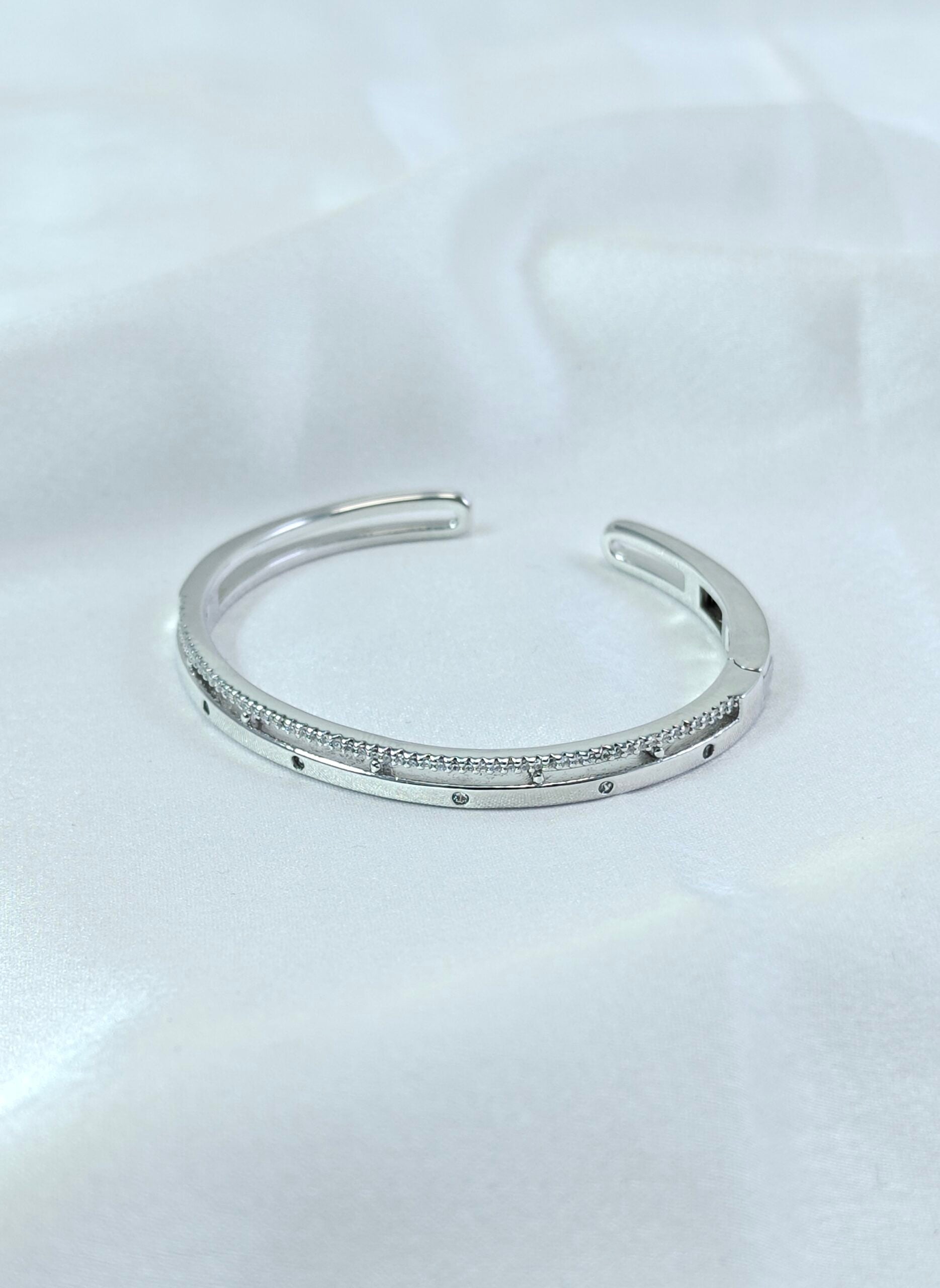 Silver bracelet with small stones on a white background