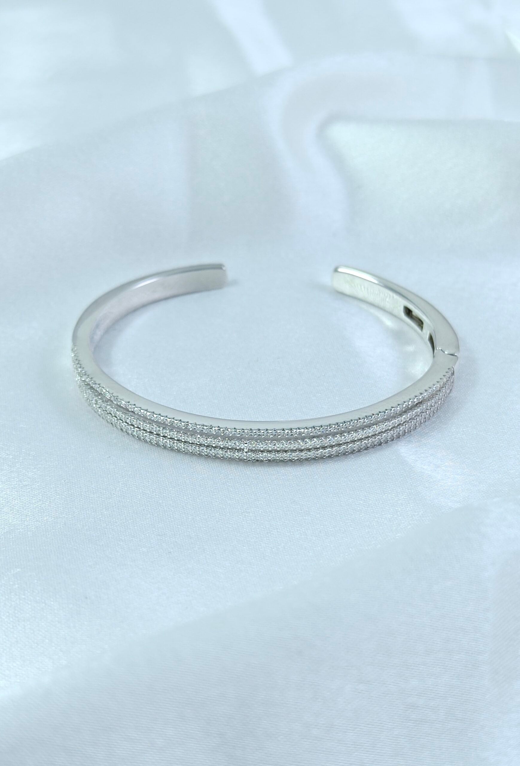 Silver bracelet on a white fabric background