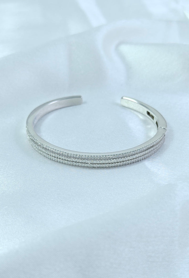 Silver bracelet on a white fabric background