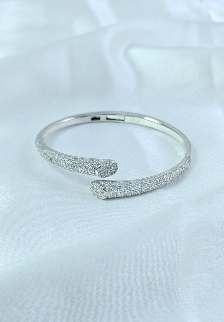 Silver bangle with textured design on a light gray background