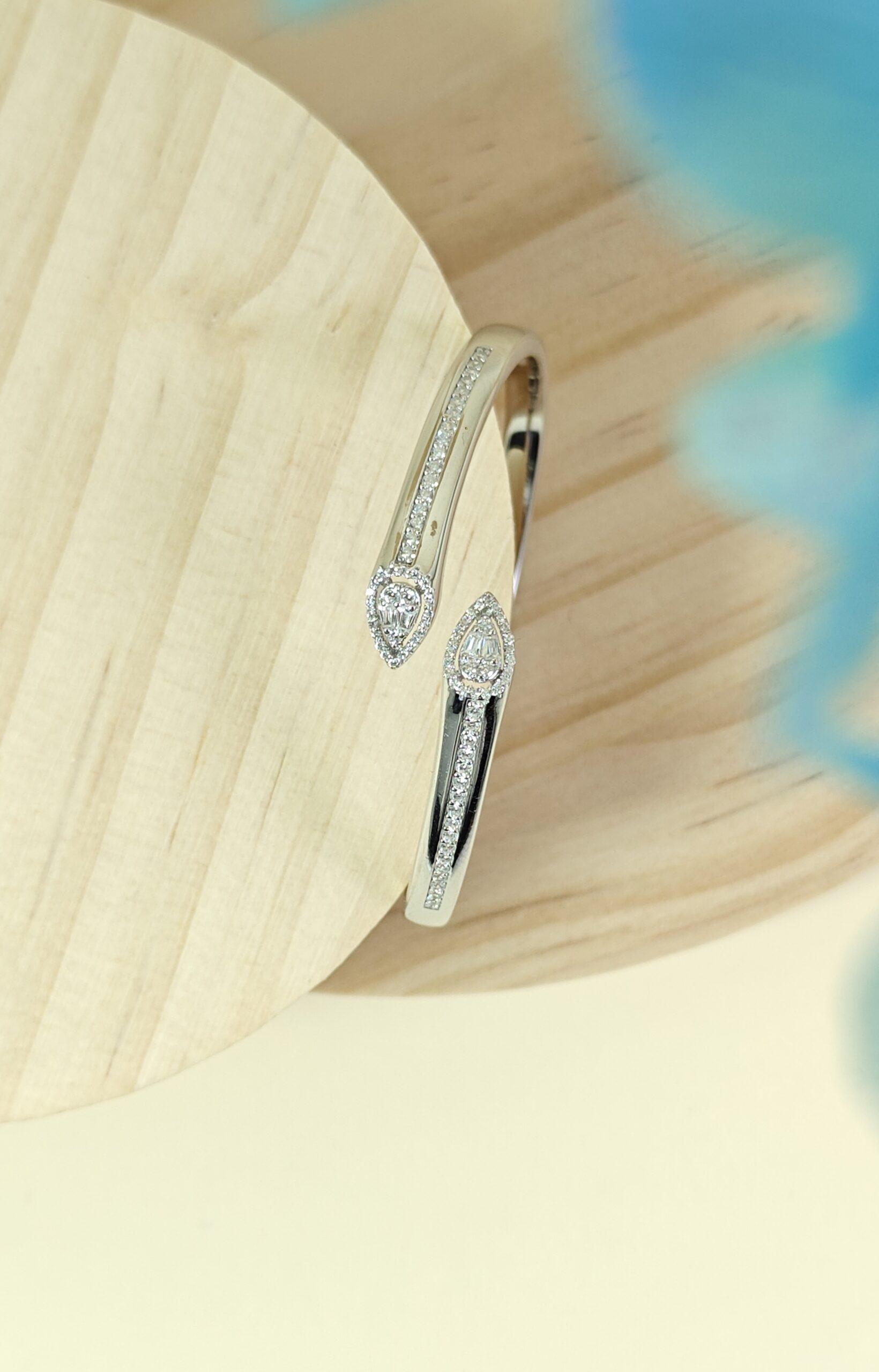 Silver hoop earrings with heart-shaped gemstones on a wooden surface