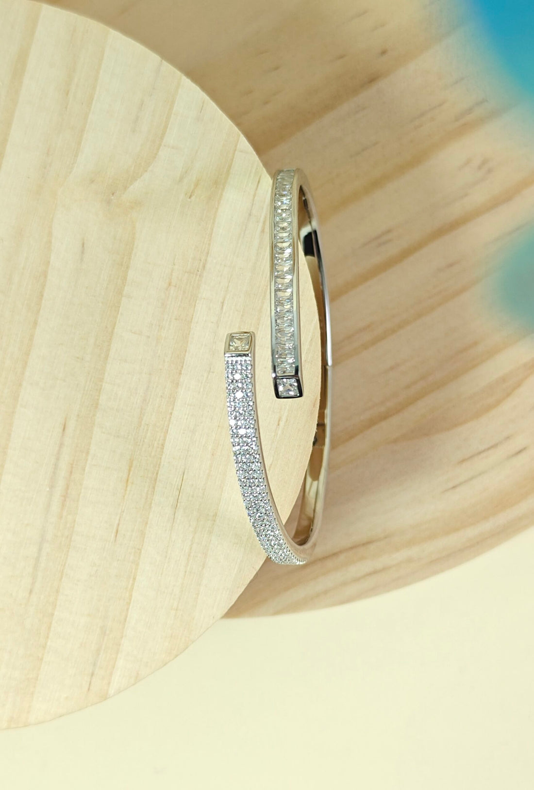 Silver bracelet with small diamonds on a light wood background