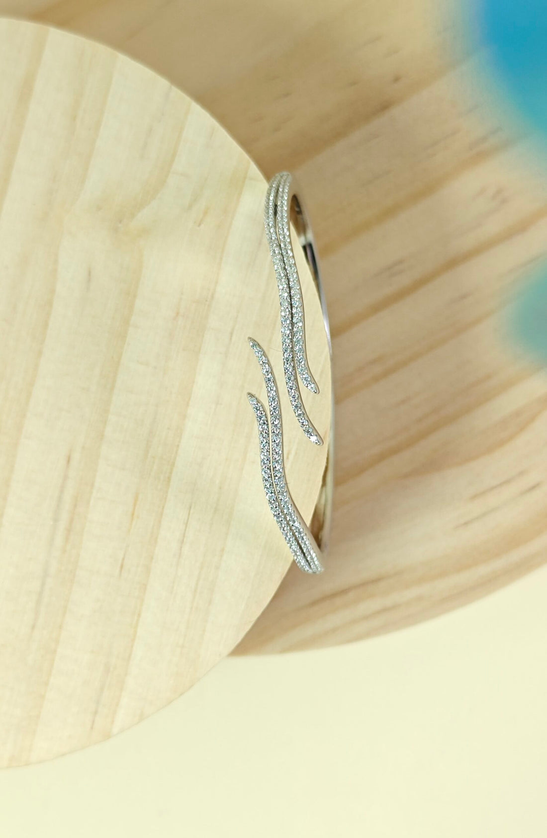 Silver earring on a wooden surface