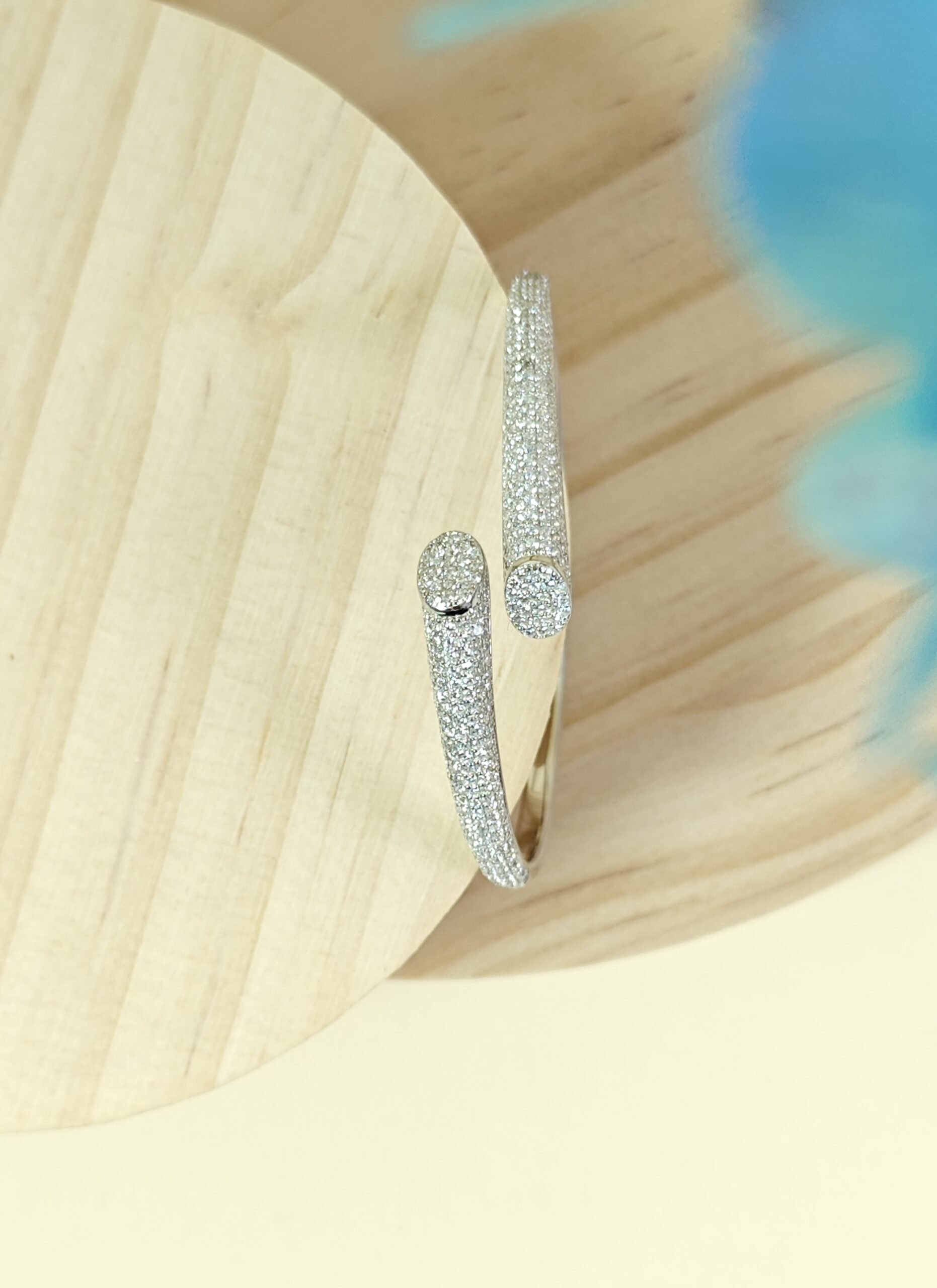 Silver bracelet with clear stones on a wooden surface