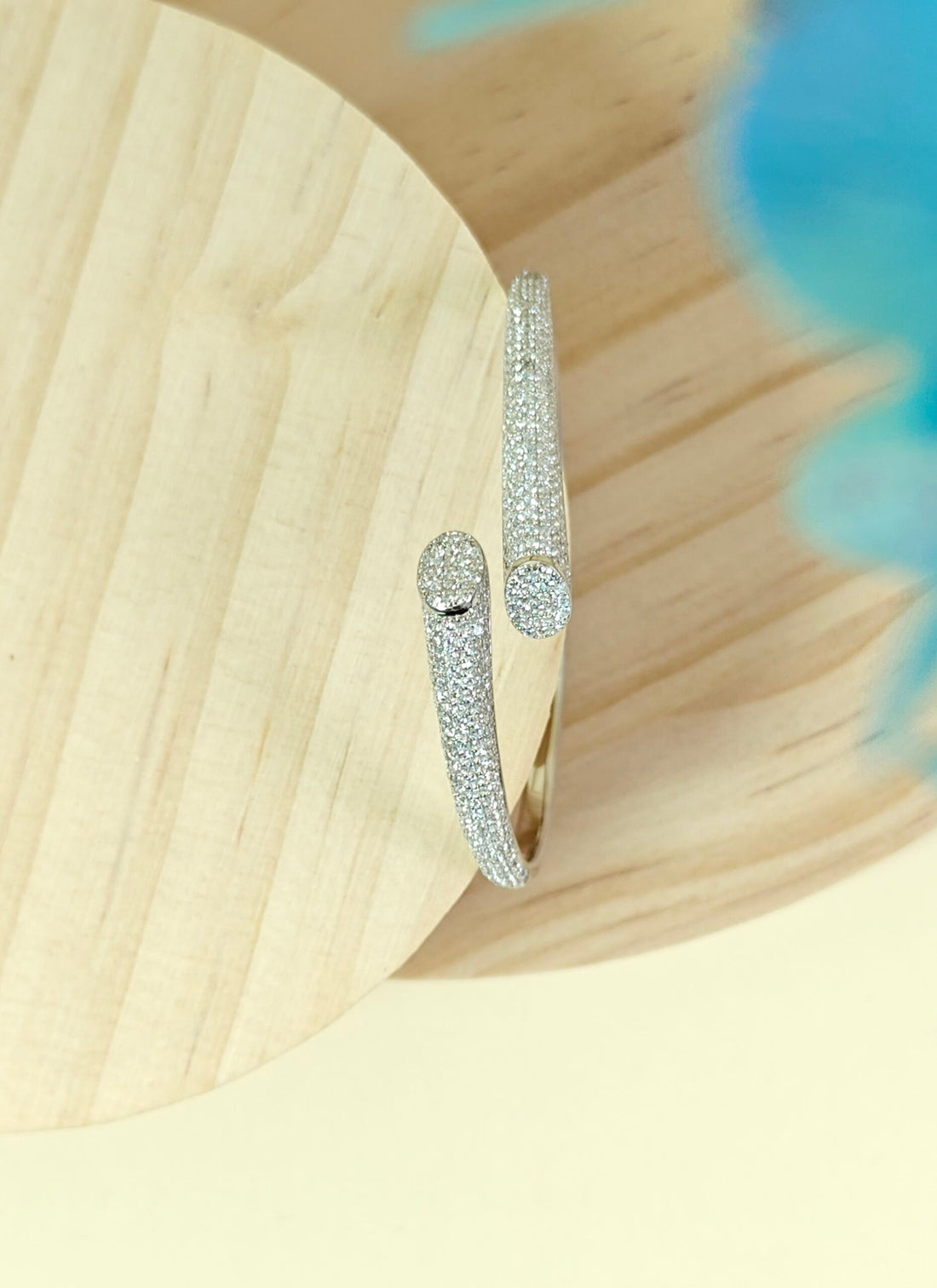 Silver bracelet with clear stones on a wooden surface