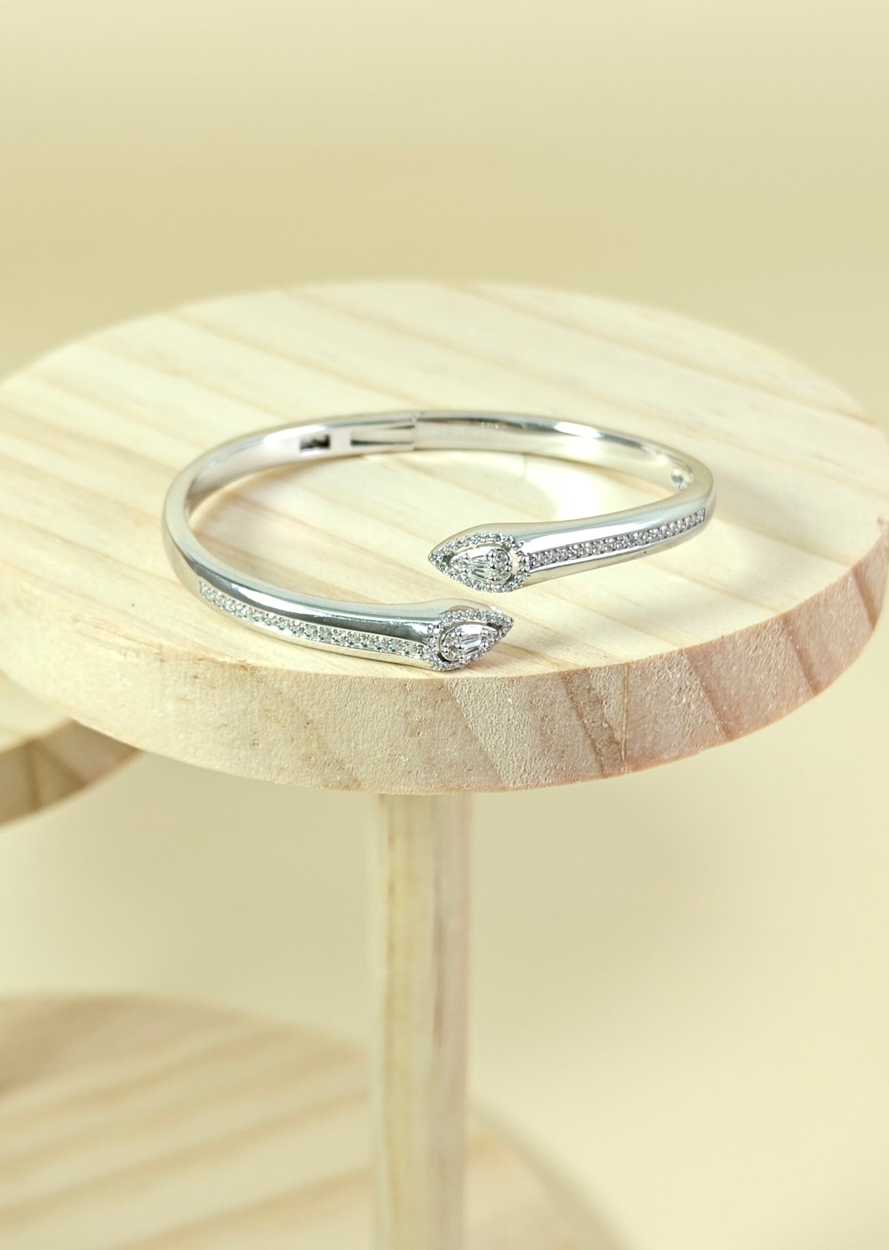 Silver bracelet with small diamonds on a wooden surface