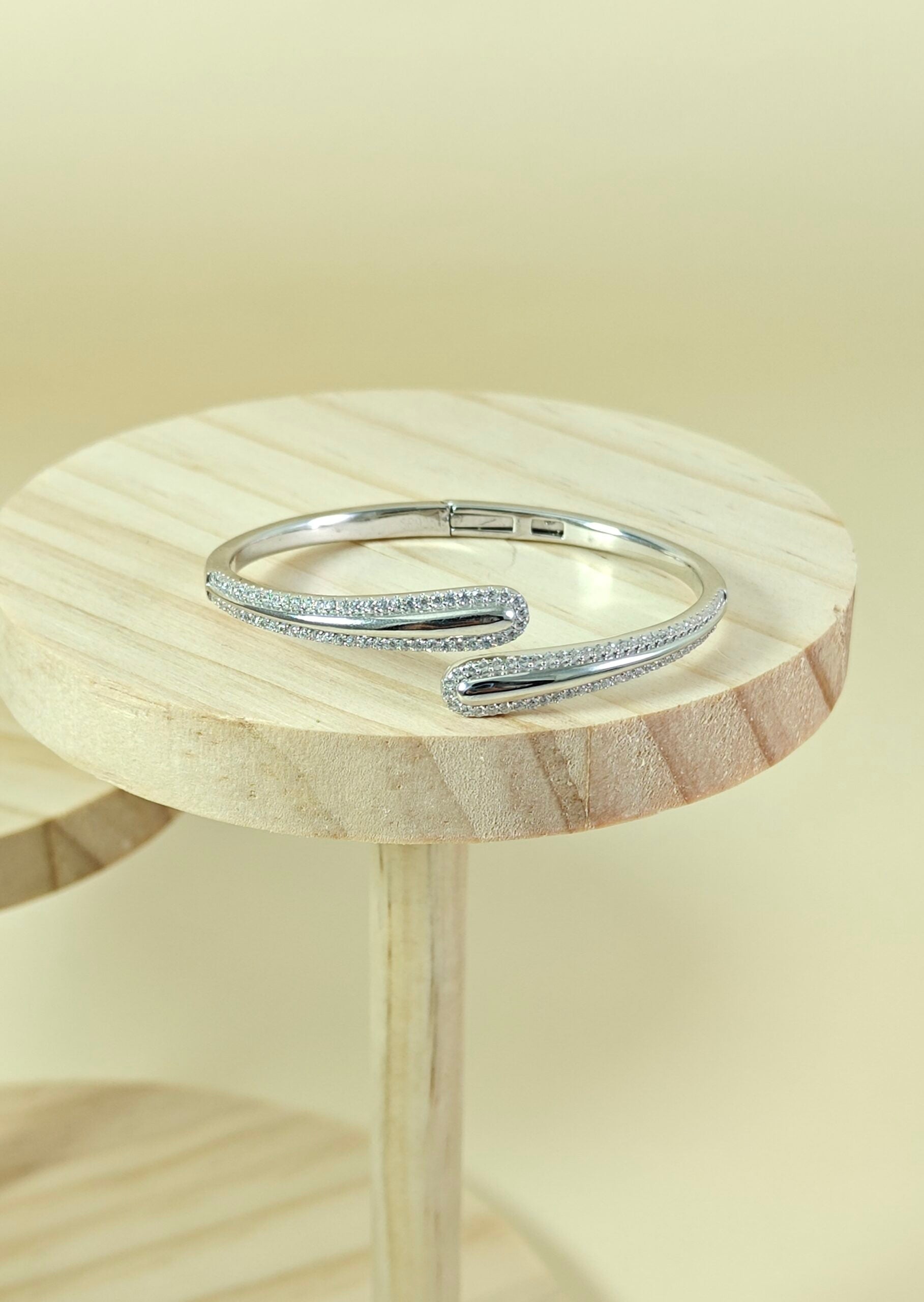 Silver bracelet on a wooden stool with a light background