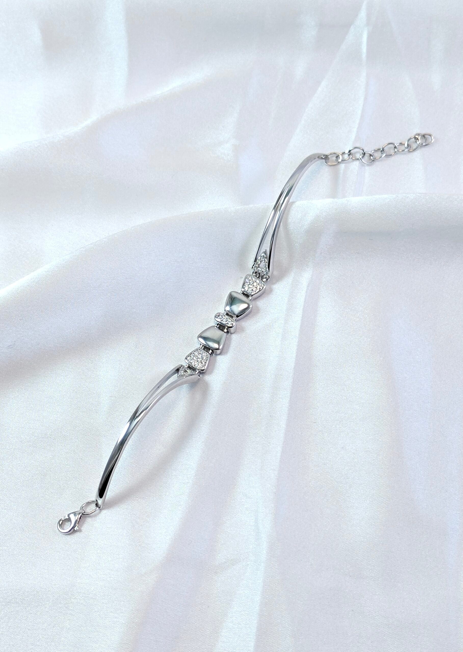 Silver bracelet with diamond accents on a white fabric background