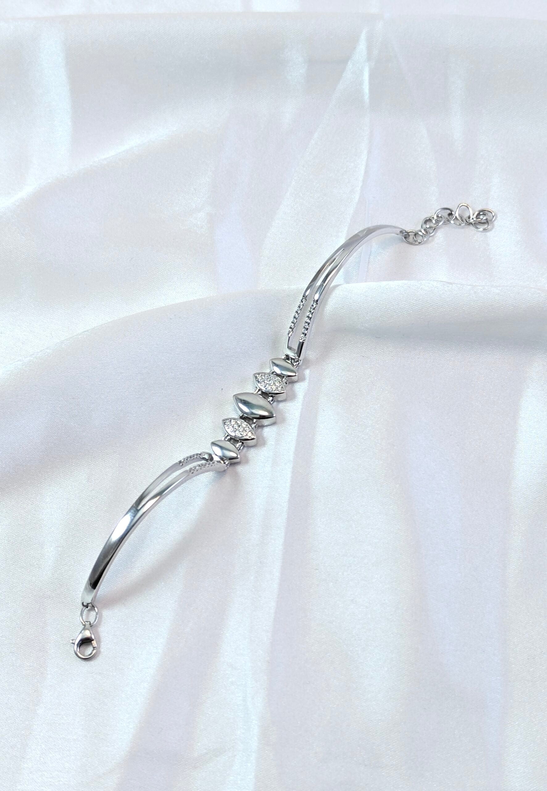 Silver bracelet on a white fabric background