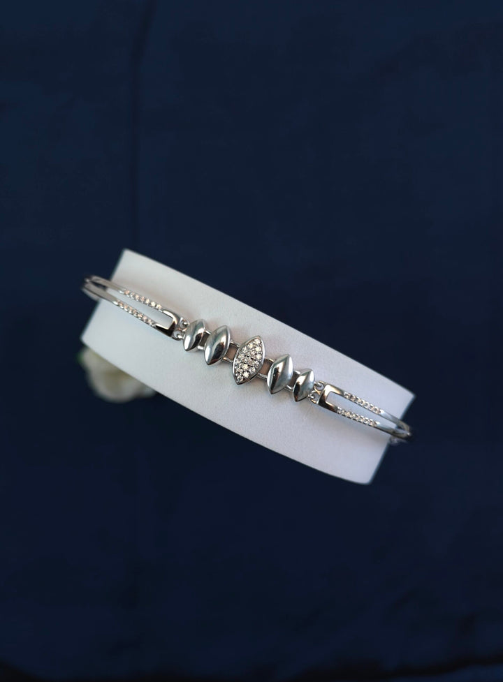 White leather bracelet with silver accents on a dark background