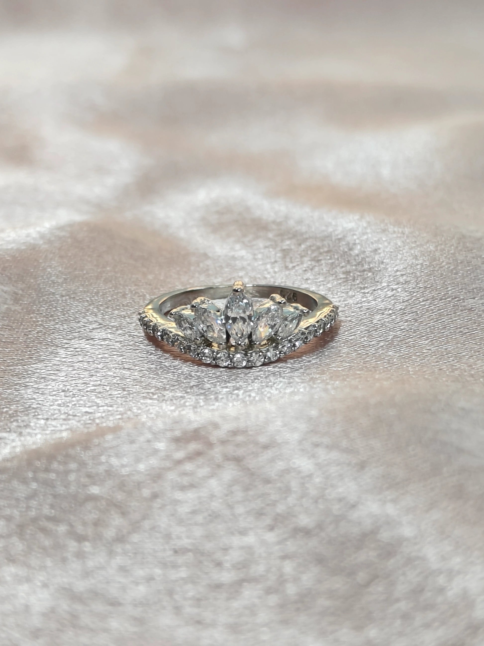 Diamond ring with a gold band on a textured surface