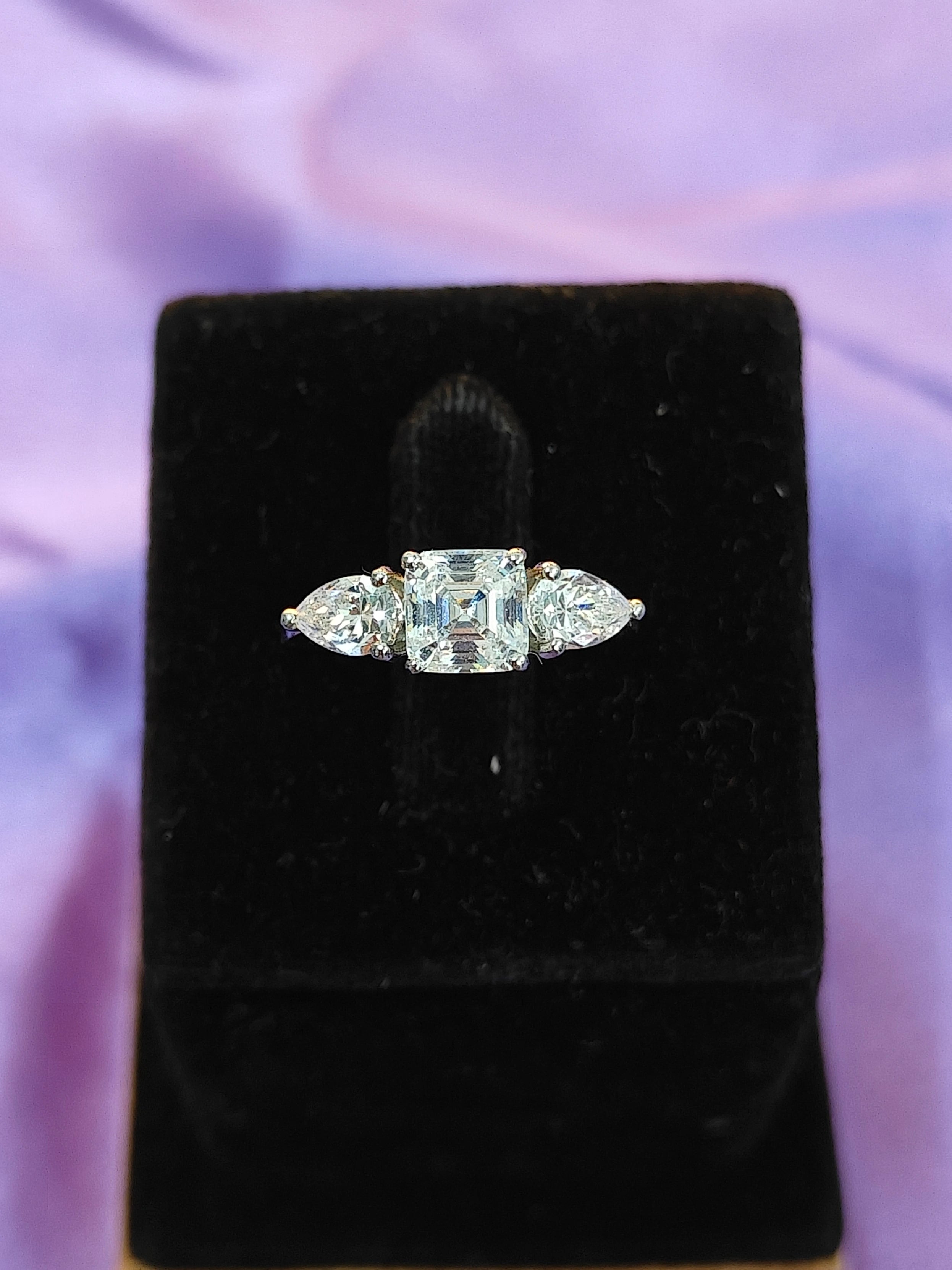 Diamond ring on a black velvet cushion with a purple fabric background