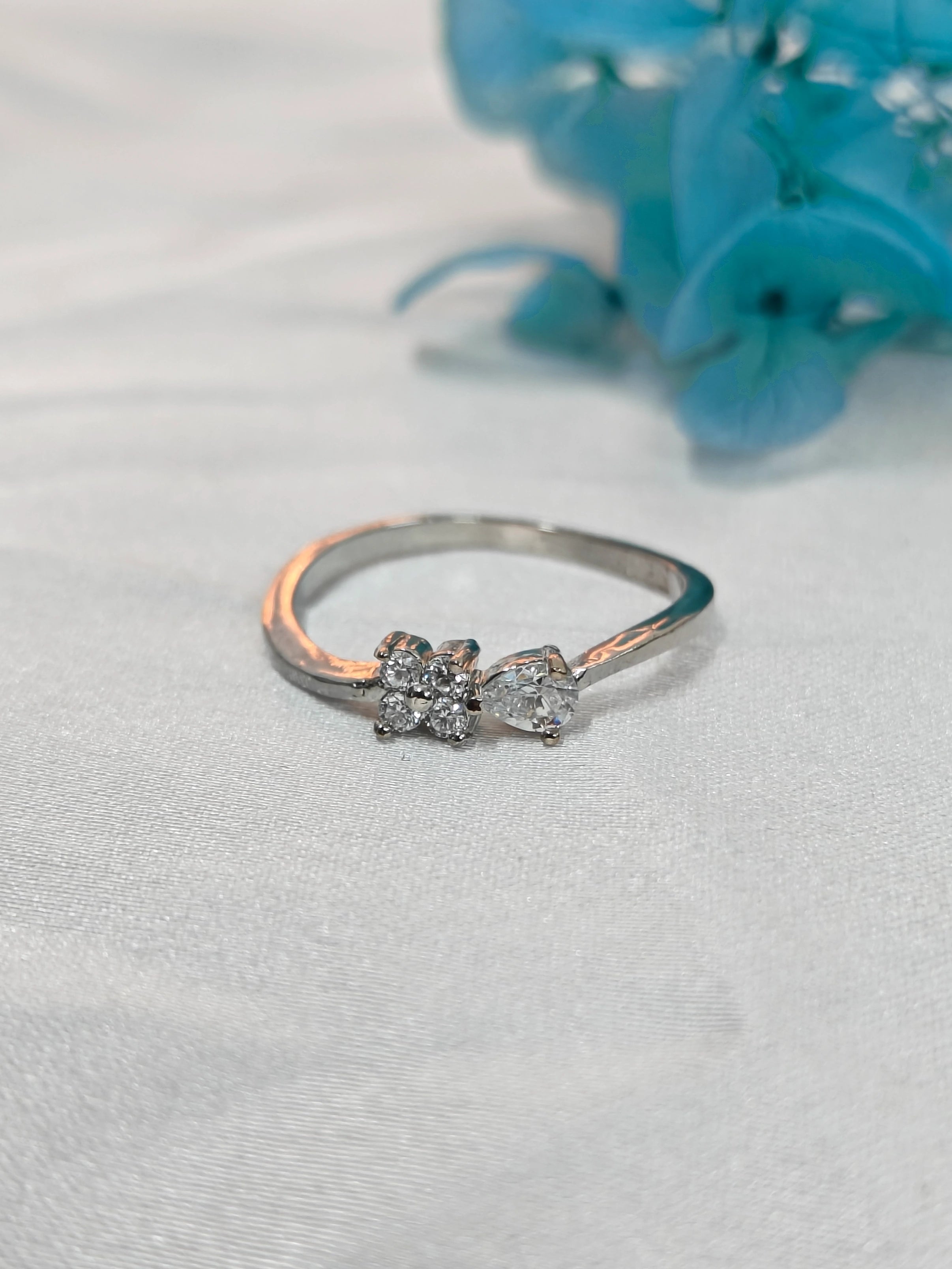 Silver ring with floral design on a light gray background