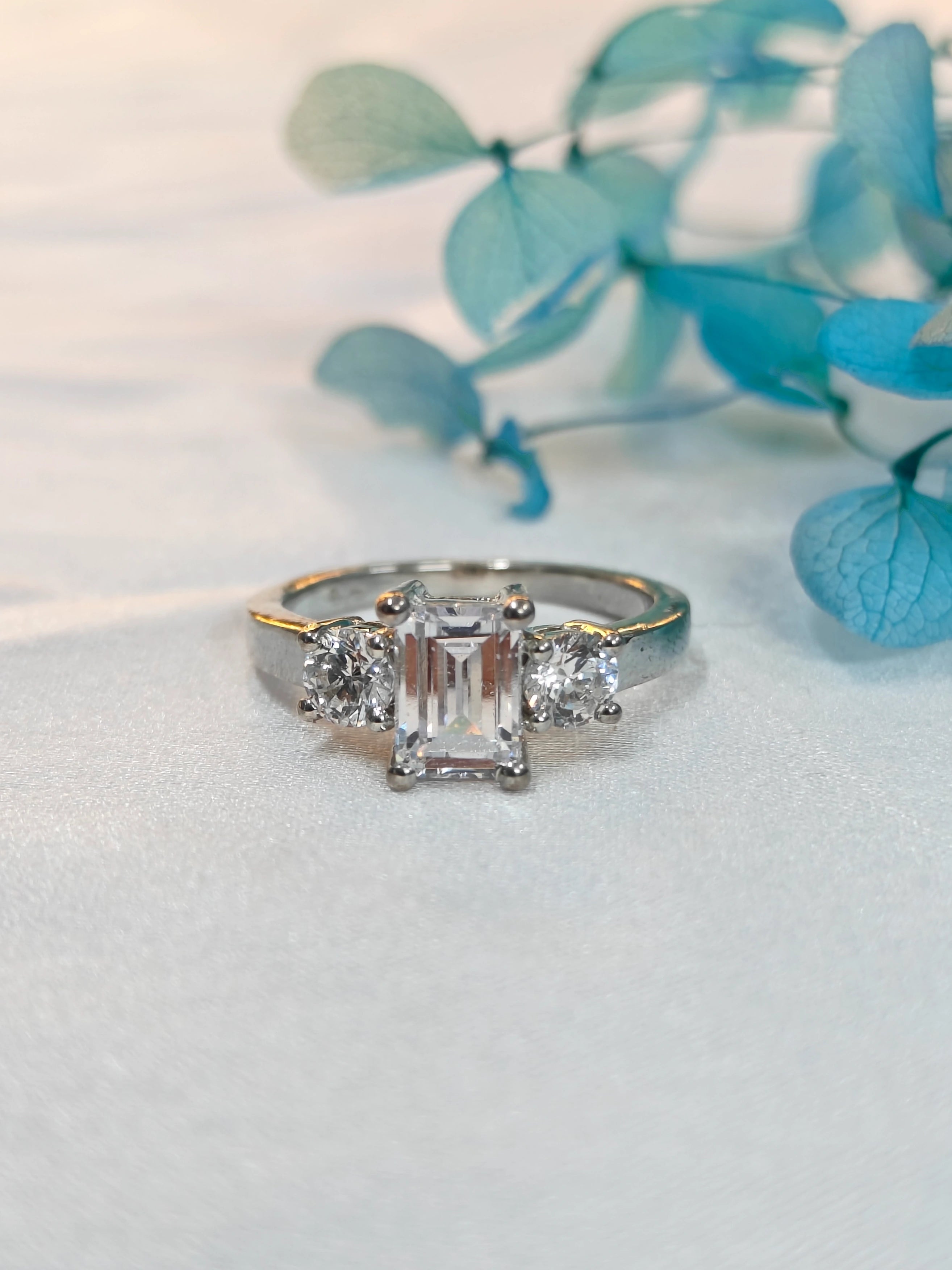Diamond ring on a light surface with blue decorative elements