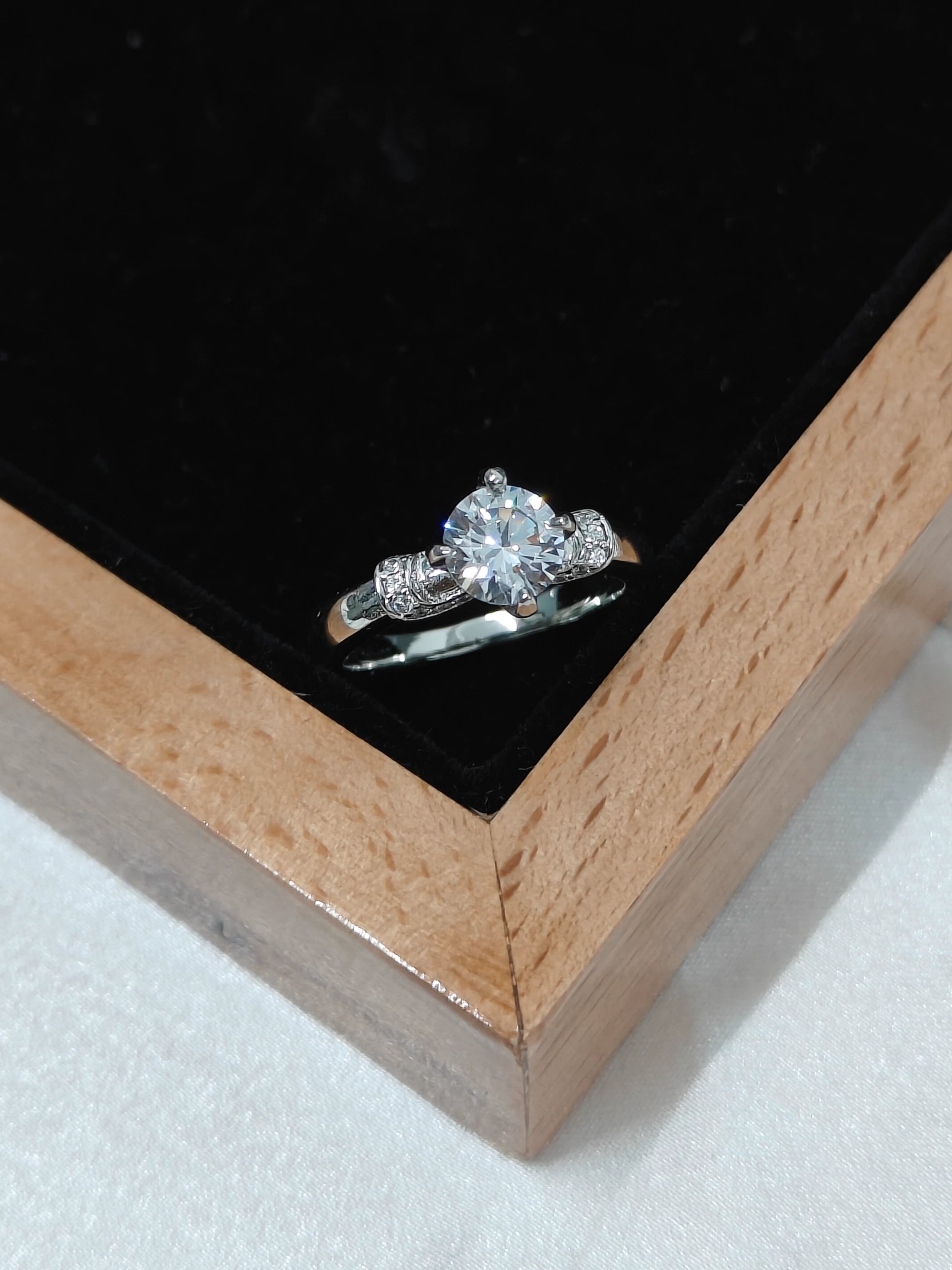 Diamond ring in a wooden box on a black background