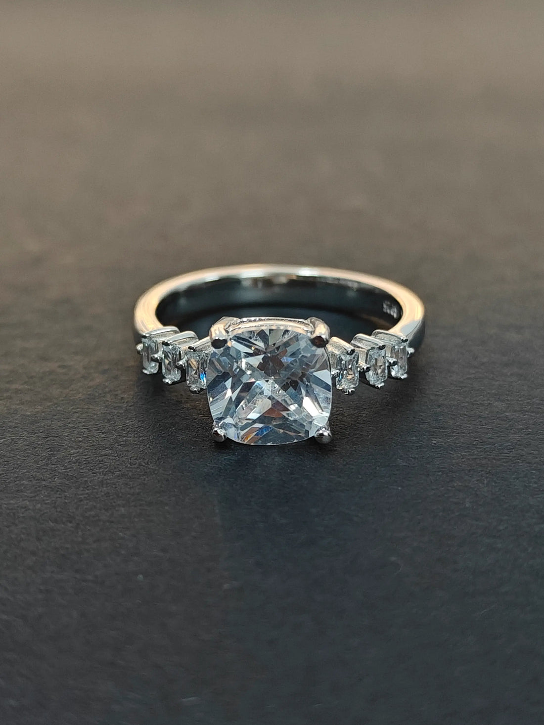 Diamond ring on a dark surface