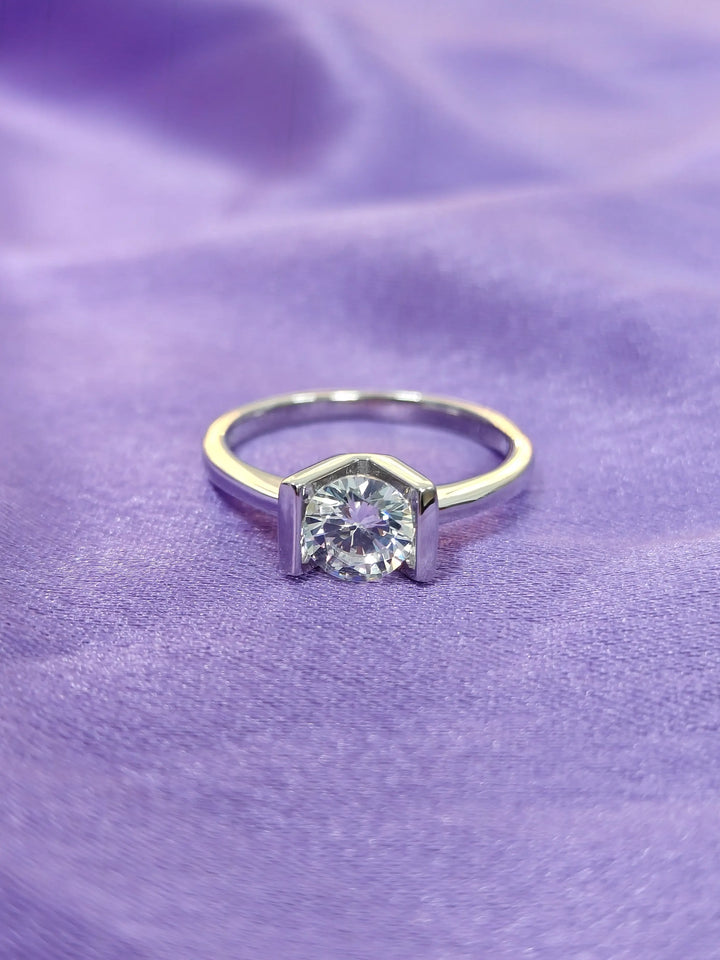 Gold ring with a diamond on a purple fabric background
