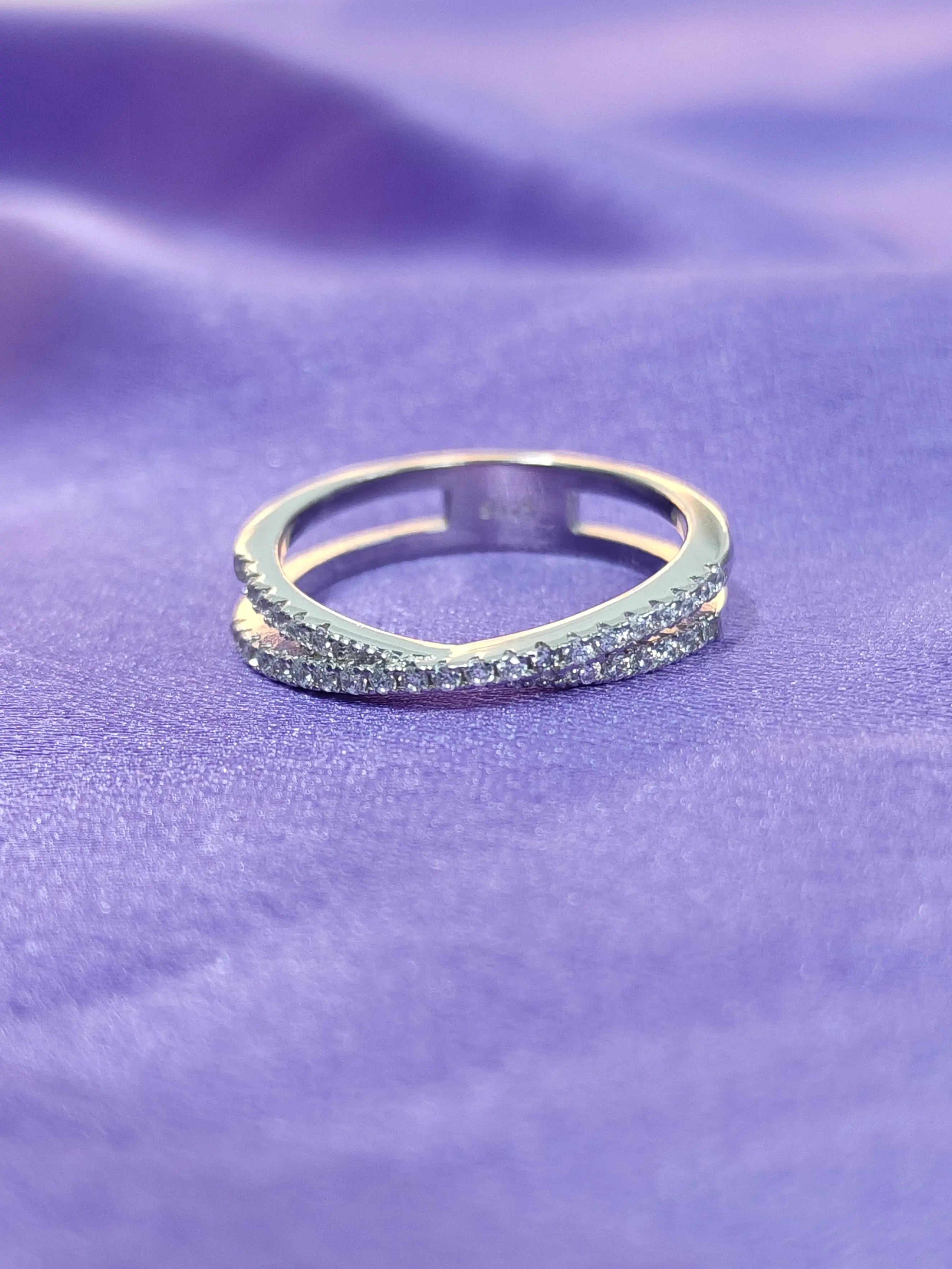 Silver ring with embedded stones on a purple fabric background