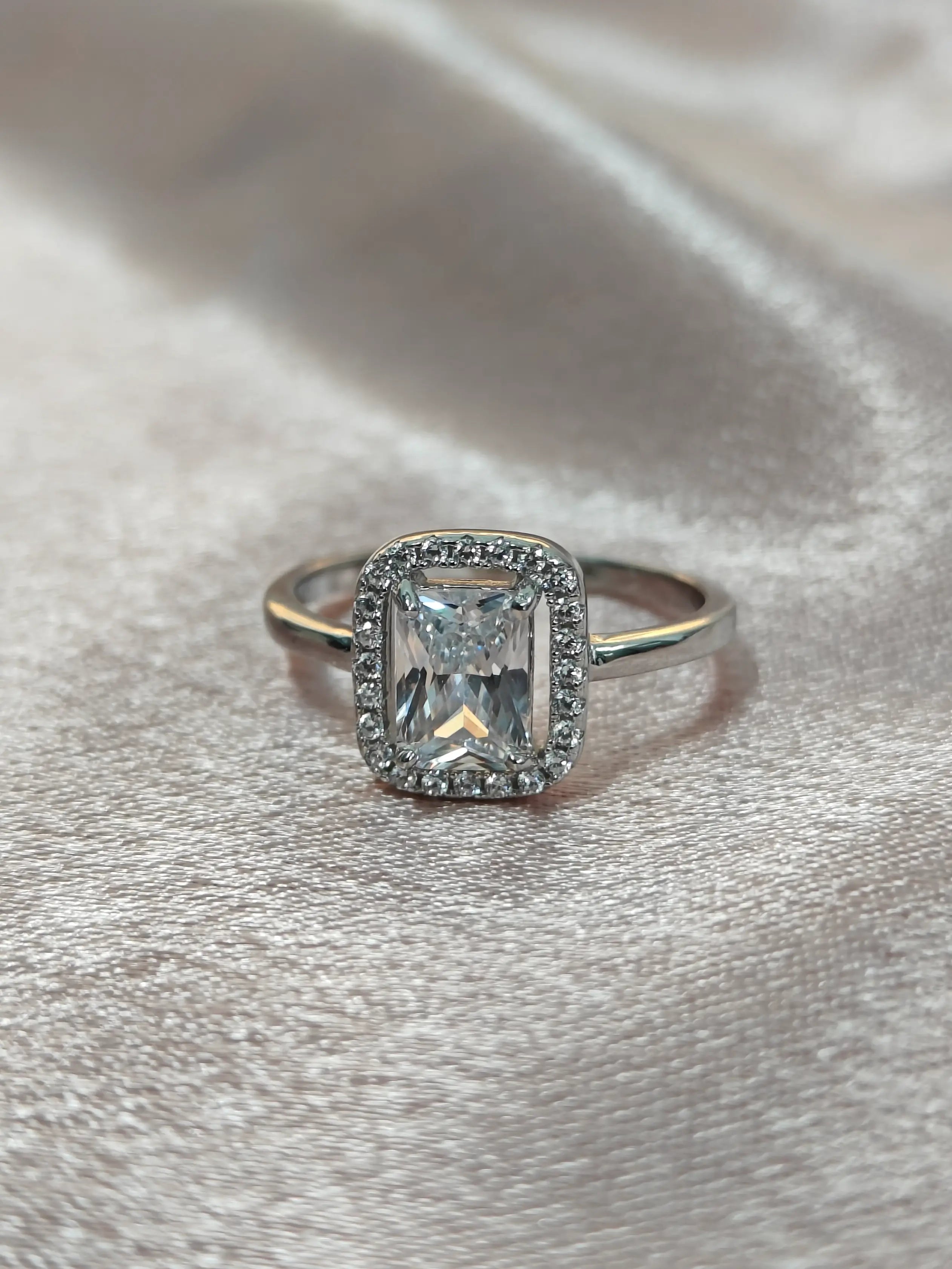 Silver ring with a diamond on a silver background