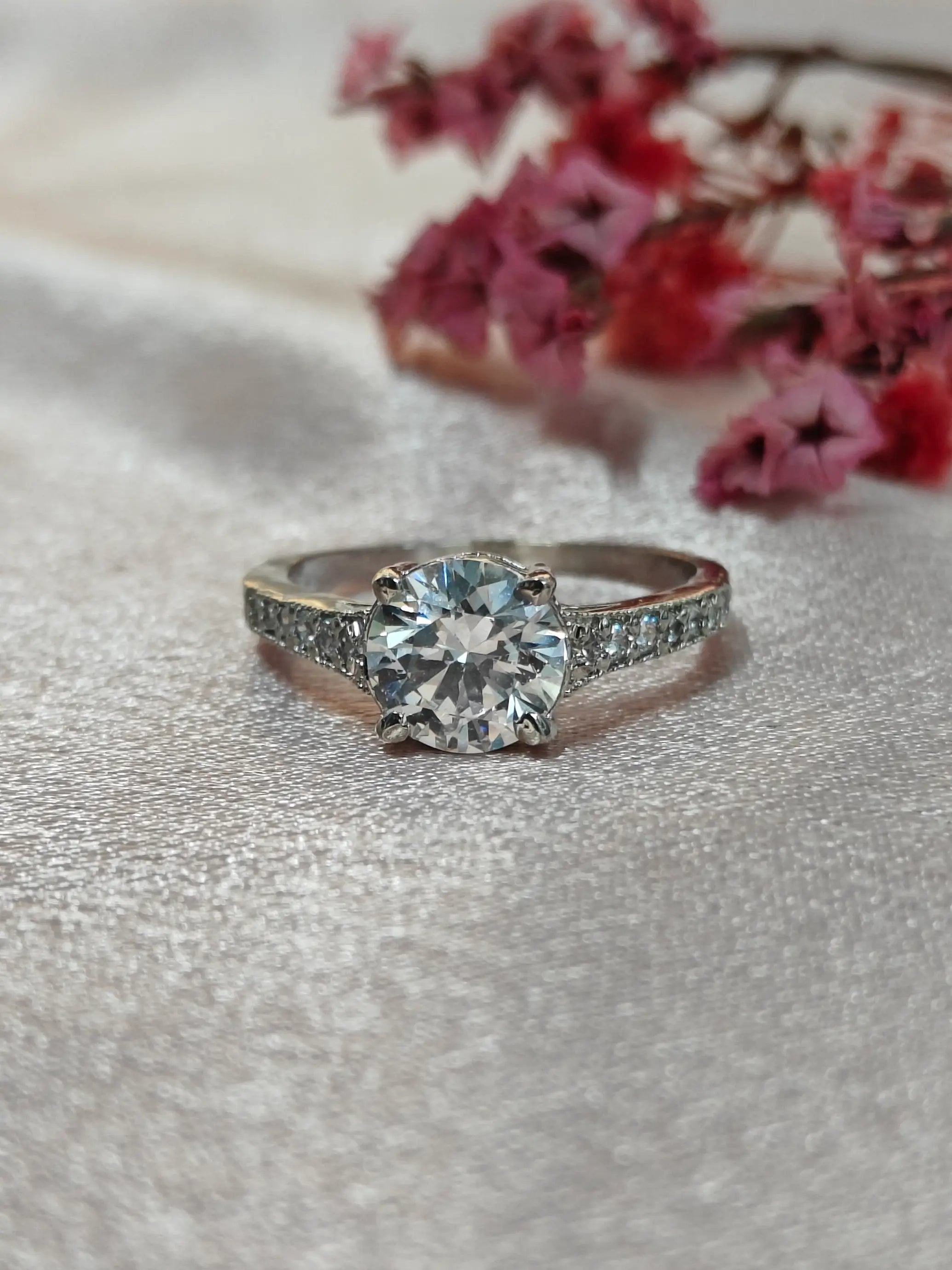 Diamond ring on a soft fabric background with pink flowers