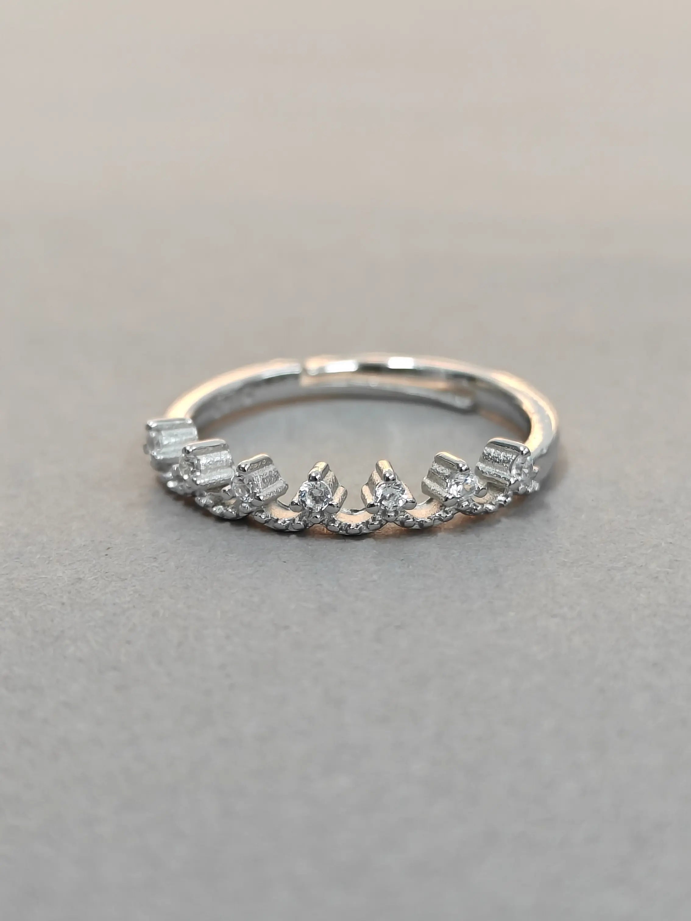 Silver ring with diamonds on a gray background