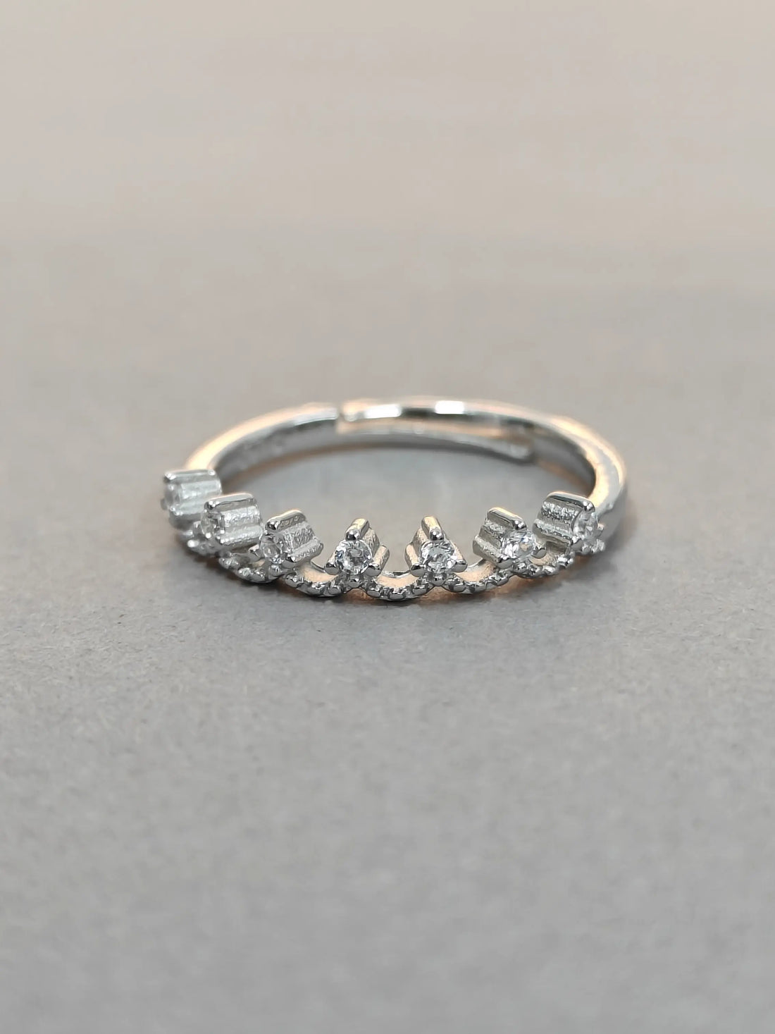 Silver ring with diamonds on a gray background