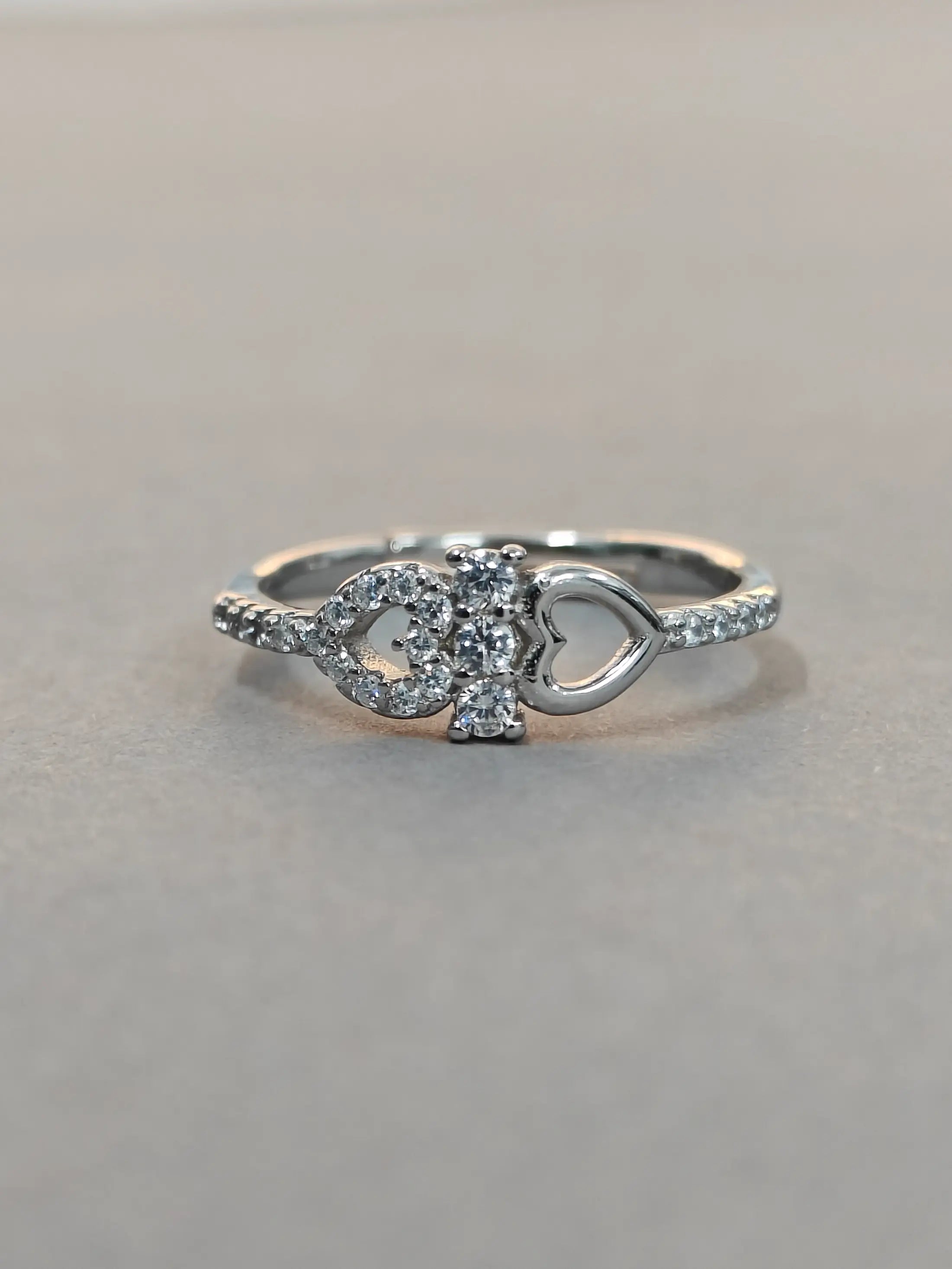 Silver ring with gemstones on a gray background