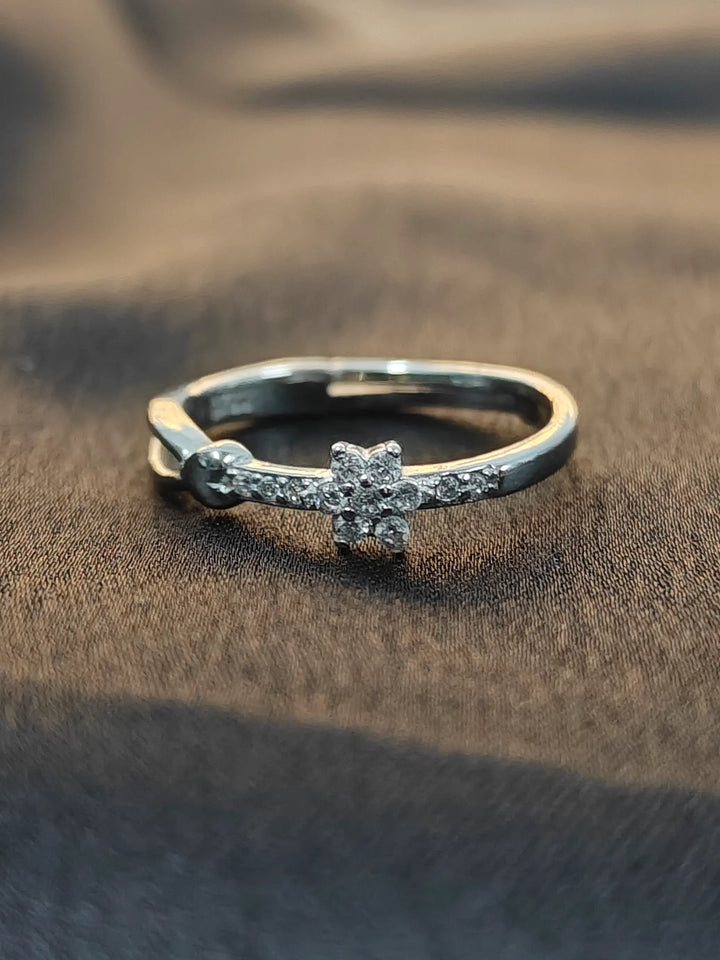 Silver ring with a diamond on a brown fabric background