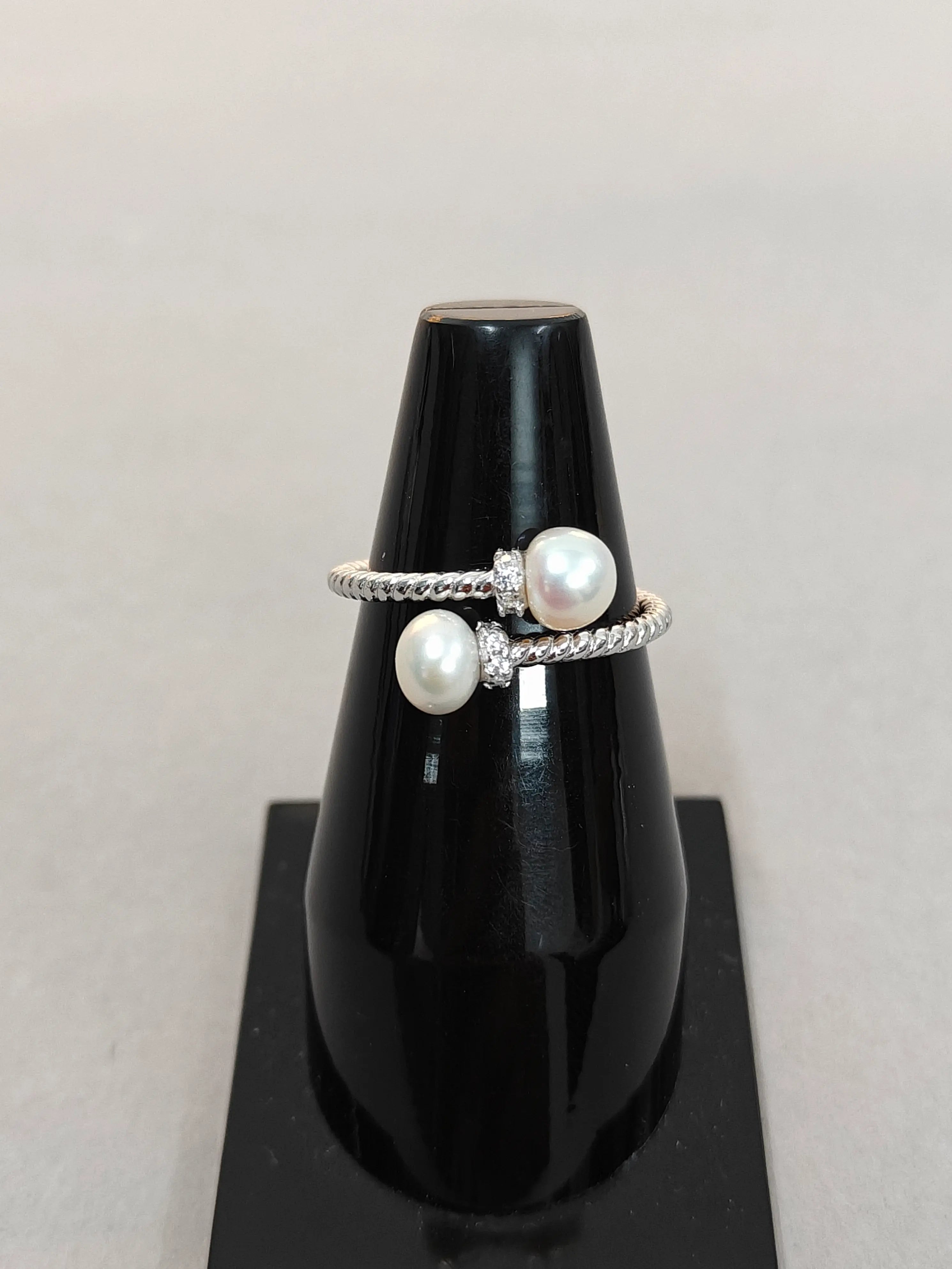 Pearl ring on a black stand with a light gray background