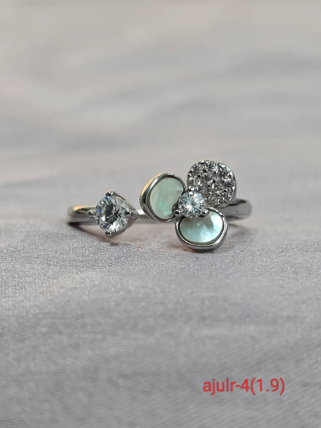 Three gemstone rings on a gray fabric background