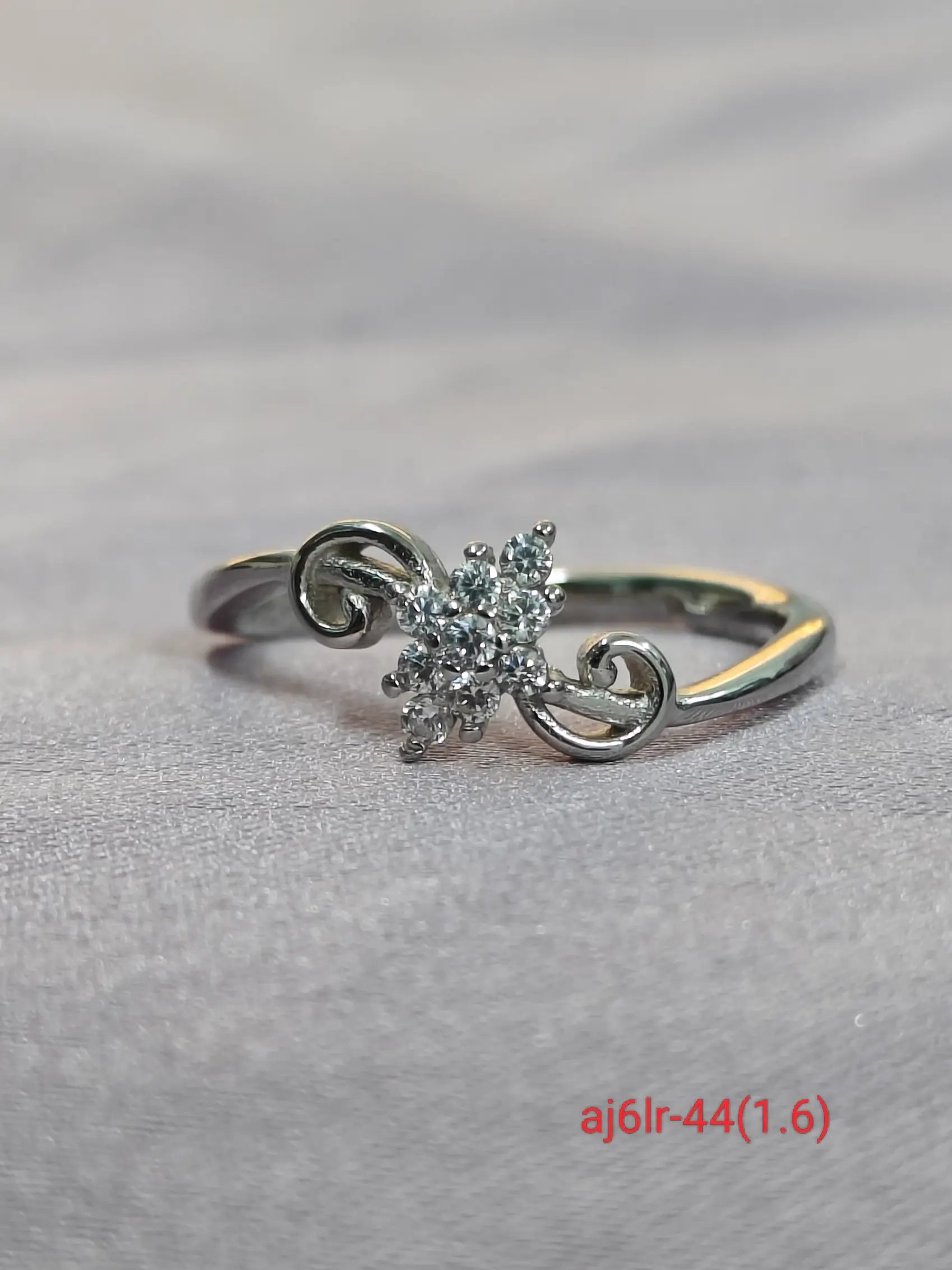 Silver ring with a diamond on a gray background