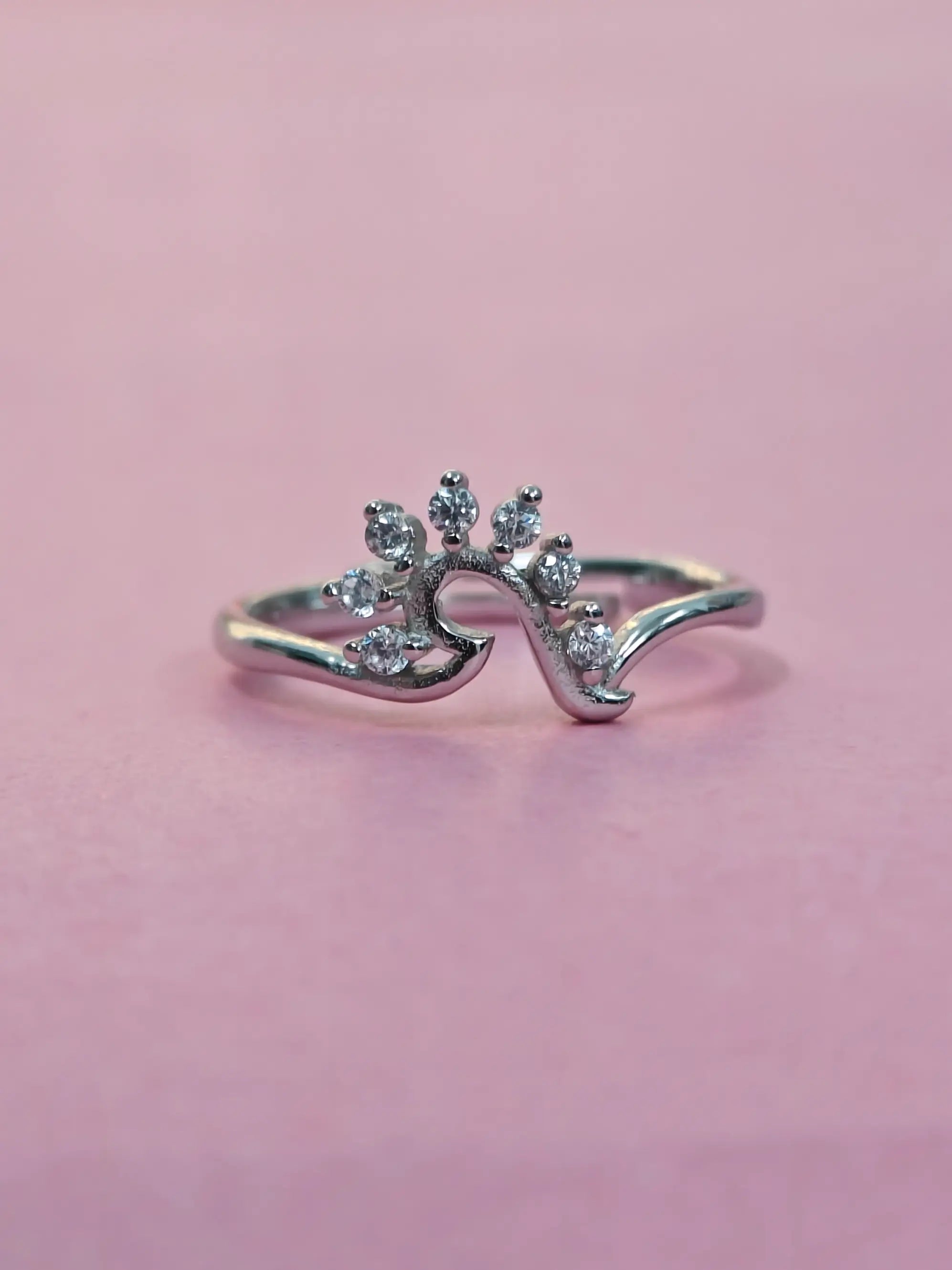 Silver ring with small diamonds on a pink background